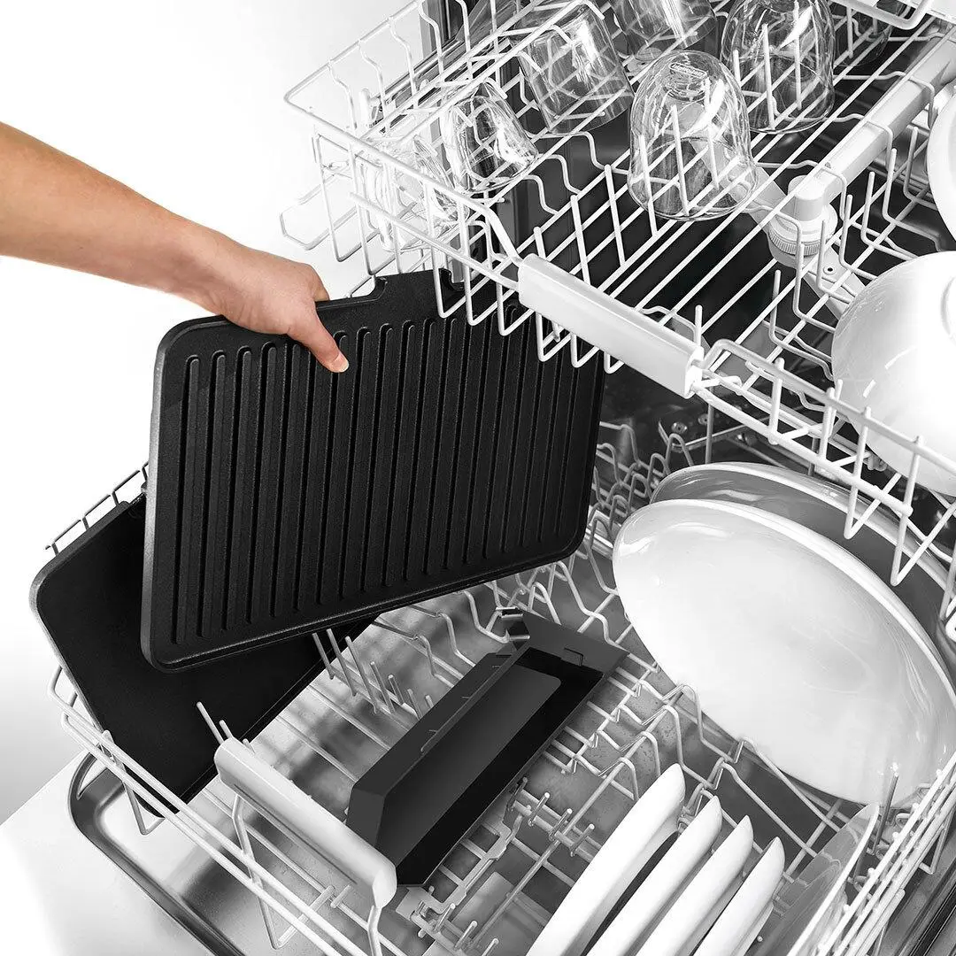 Zmywarka z czarną, podobną do rusztu tacą wkładaną do środka. Widoczne są naczynia i szklanki.