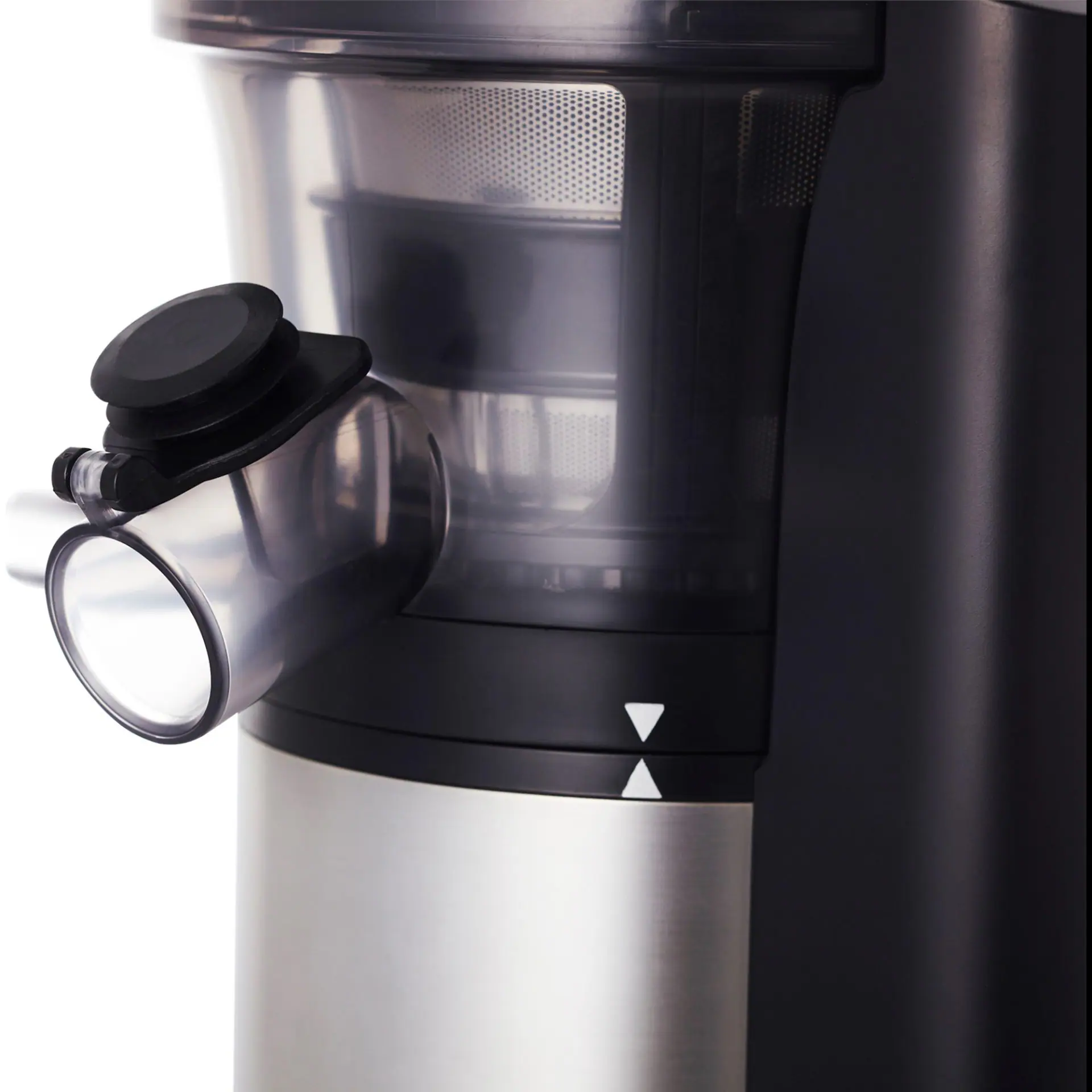 Zbliżenie na wyciskarkę. Srebrne i czarne części. Przezroczysty plastikowy wylew, białe tło.