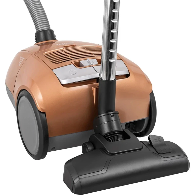 Złoty odkurzacz z wężem, rurą i szczotką do podłóg. Stoi pionowo.