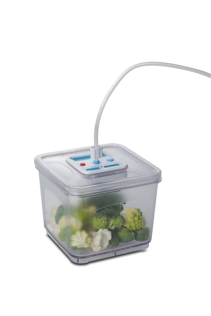 Przezroczysty pojemnik na żywność z brokułami i kalafiorem. Przezroczysta rurka łączy się z pokrywą z przyciskami.