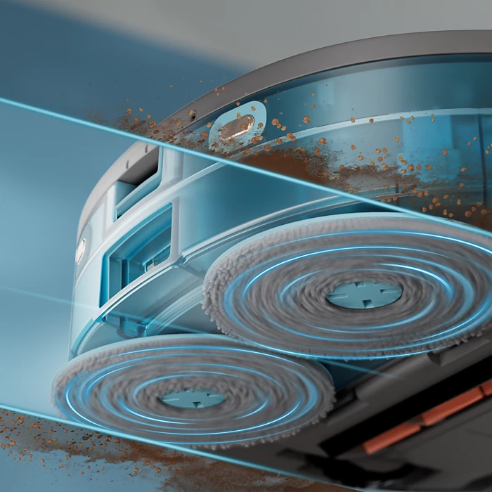 Automatyczny odkurzacz do podłóg z dwiema obrotowymi nakładkami czyszczącymi. Urządzenie jest niebiesko-szare, ze śladami wody i resztkami czyszczenia.