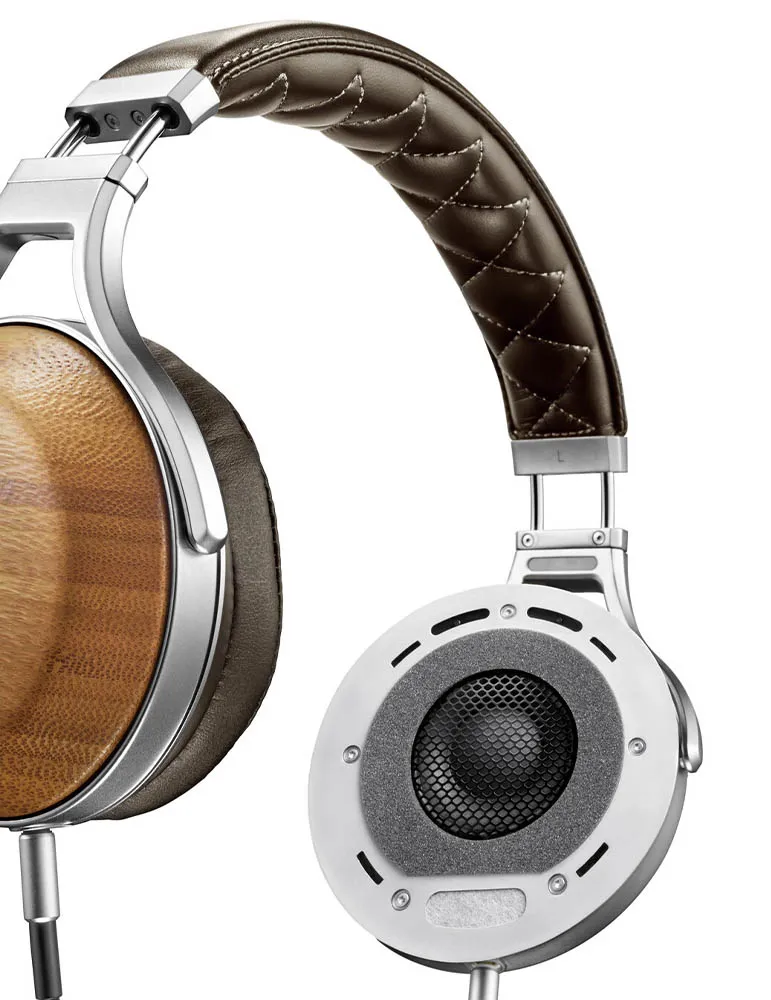 Zbliżenie słuchawek z brązowym skórzanym pałąkiem i drewnianymi nausznikami. Widoczne srebrne metalowe detale. Tło jest białe.