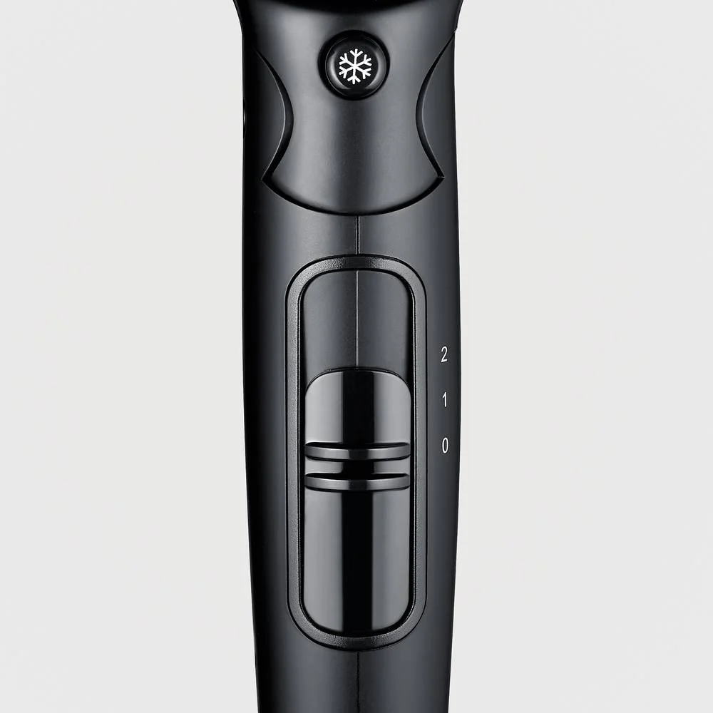 Zbliżenie czarnego uchwytu suszarki do włosów. Posiada przycisk w kształcie płatka śniegu oraz przełącznik z ustawieniami 0, 1 i 2.