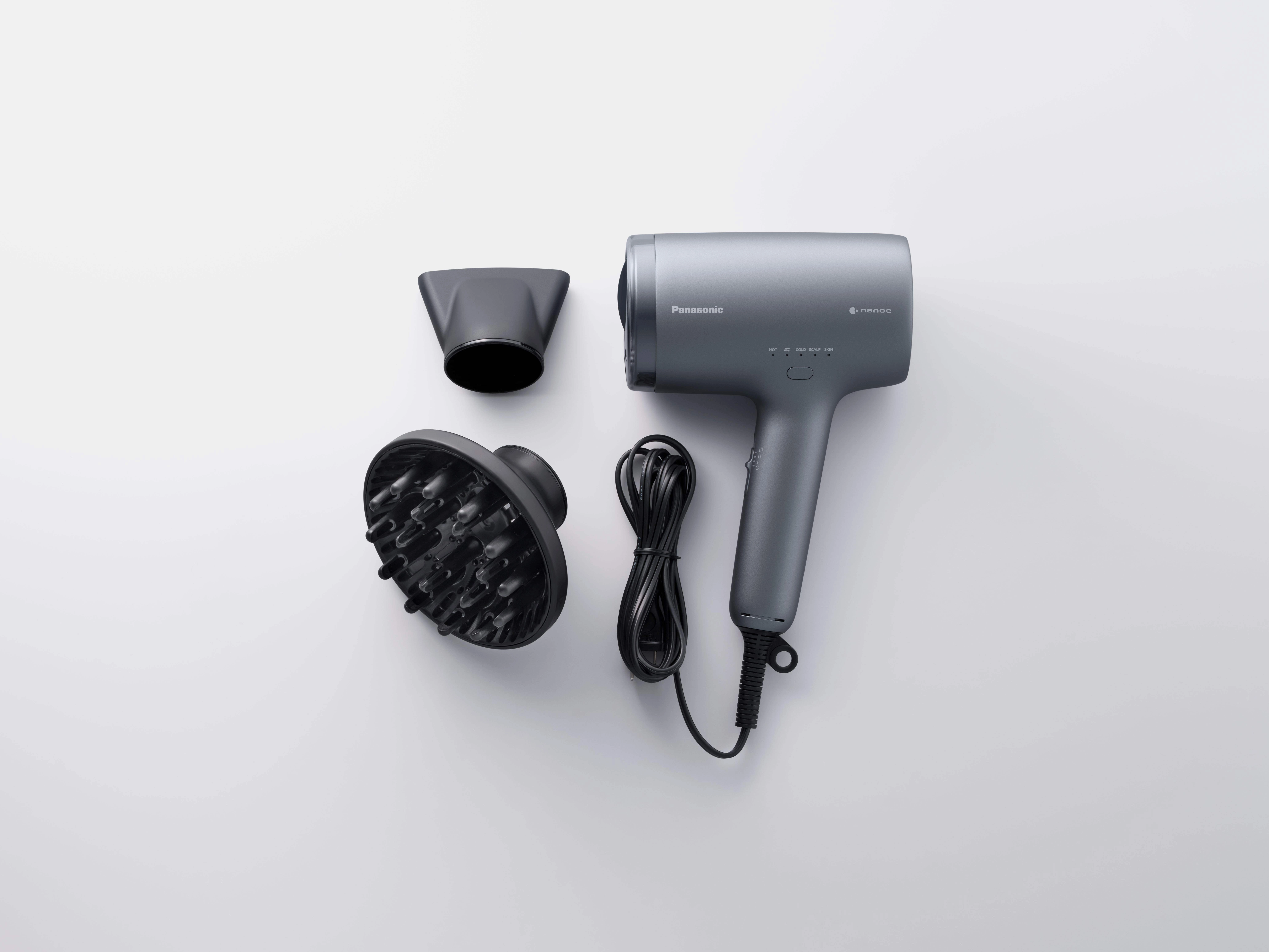 Szara suszarka do włosów Panasonic z akcesoriami i czarnym kablem, ułożona na białej powierzchni.