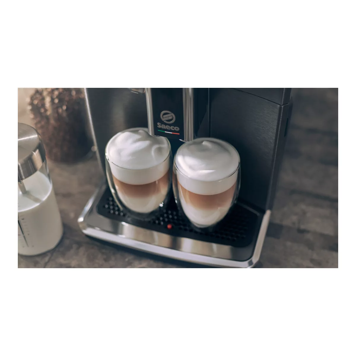 Ekspres do kawy wydający dwie filiżanki latte macchiato ze spienionym mlekiem.