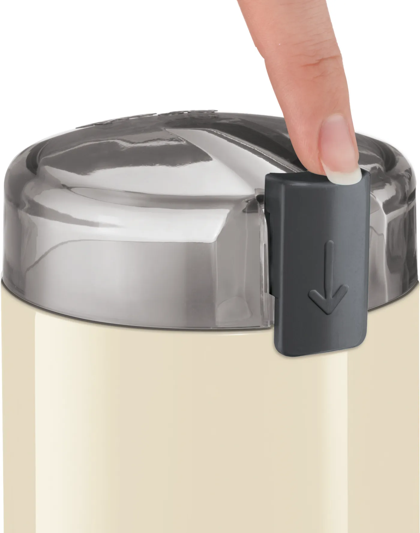 Zbliżenie białego pojemnika ze srebrną pokrywą. Palec naciska szary przycisk.