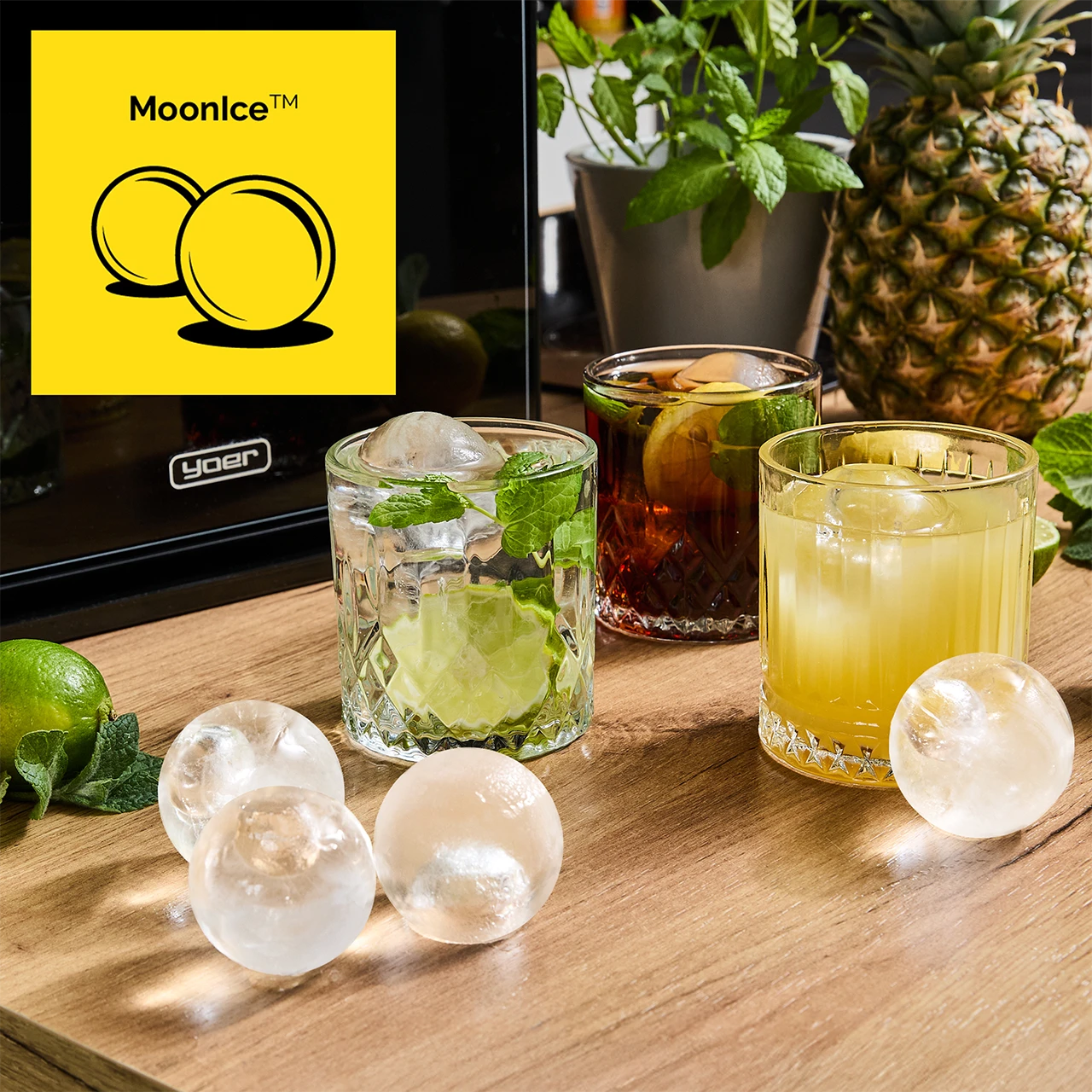 Koktajle z kulami lodu, miętą i limonką. Ananas i rośliny w tle. Logo Moonice na żółtym tle.