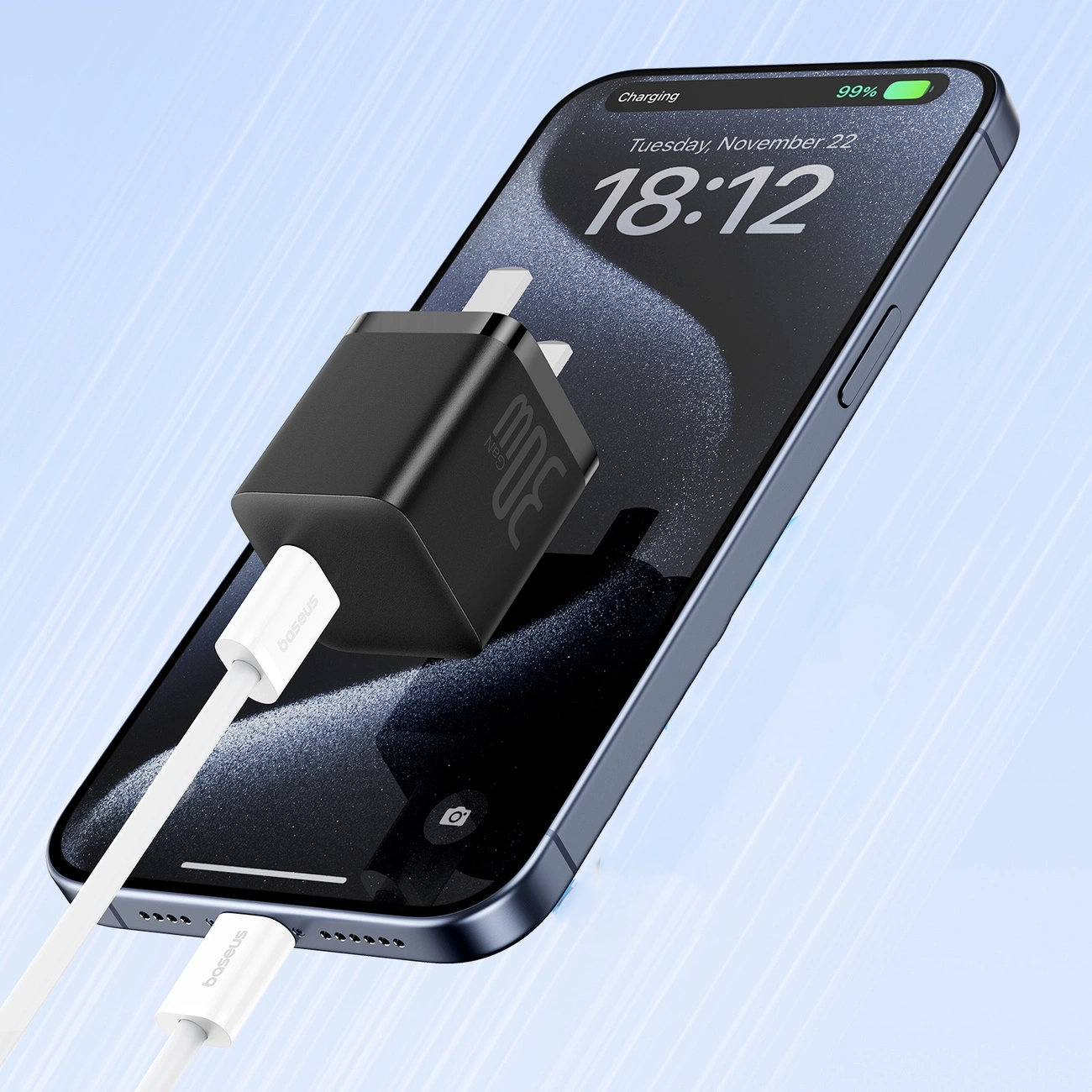 Telefon jest ładowany czarnym adapterem. Telefon wyświetla godzinę 18:12 i baterię 99%.