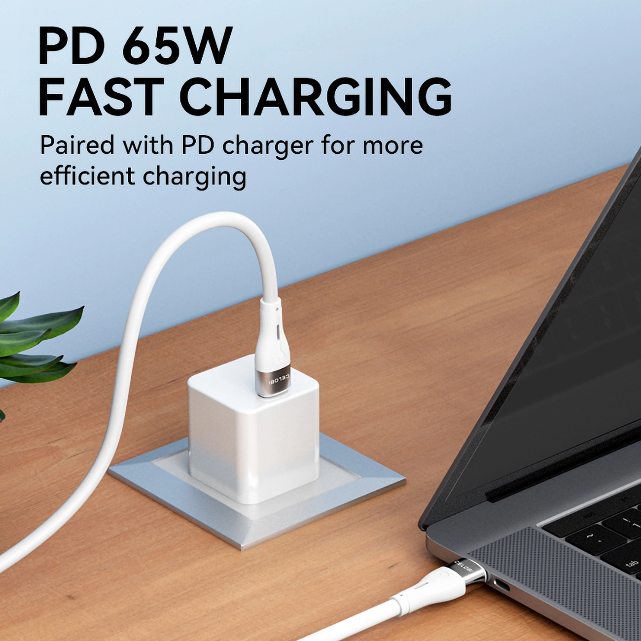 Biały kabel ładujący łączy laptopa z białą ładowarką. Tekst brzmi 'PD 65W FAST CHARGING'.