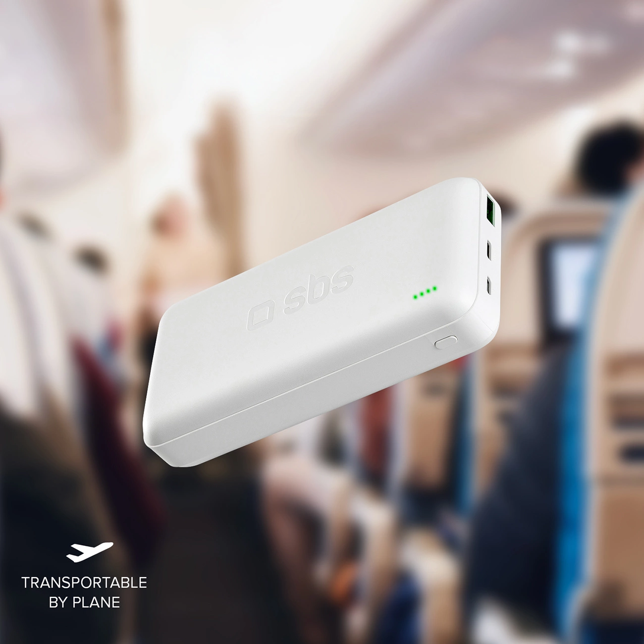 Biały power bank w samolocie. Ma markę 'sbs' i zielone światła. Tekst 'transportable by plane' jest na dole.