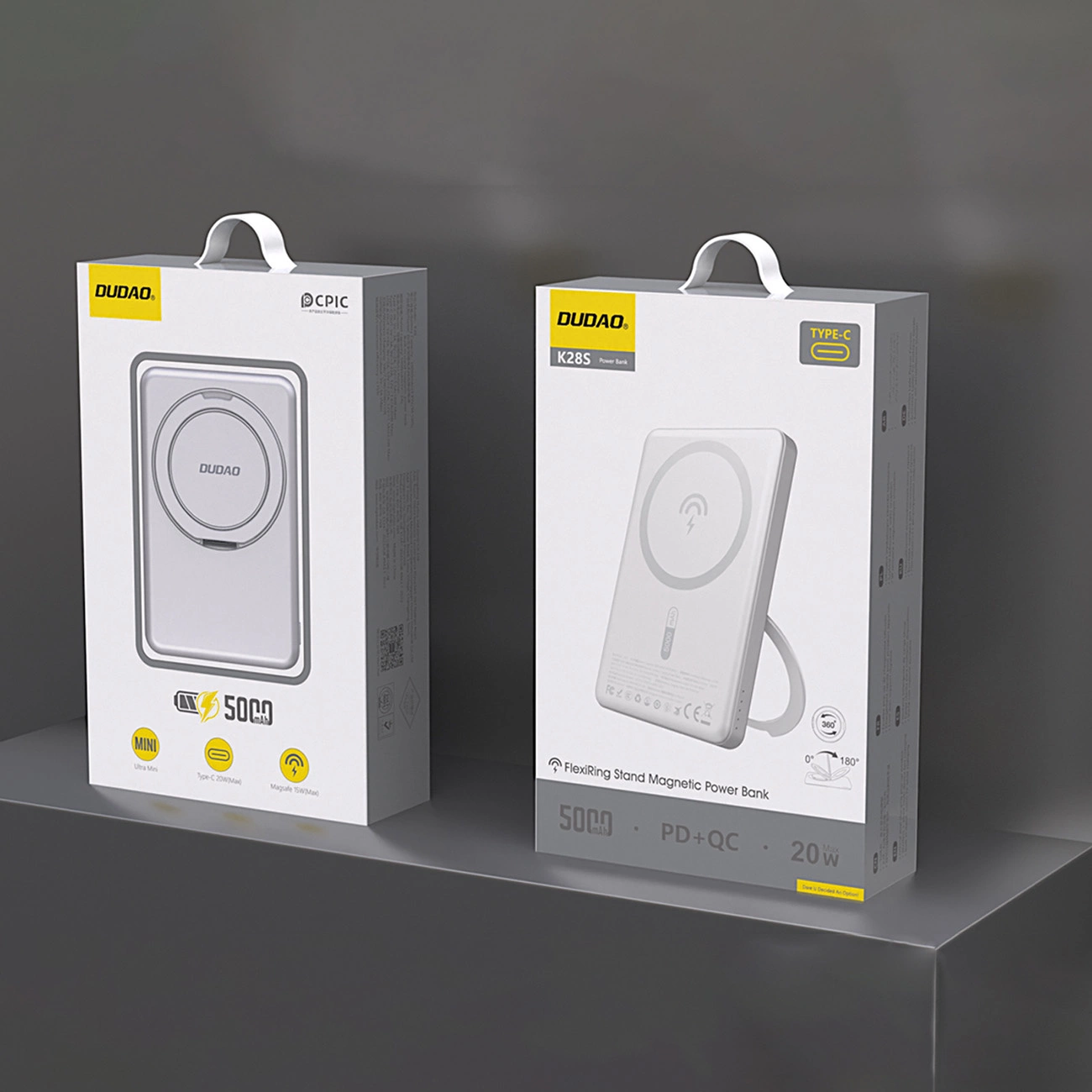 Dwa białe pudełka power bank DUDAO. Lewe pudełko mówi 'MINI', prawe 'K28S'. Oba pudełka pokazują podkładkę ładującą.