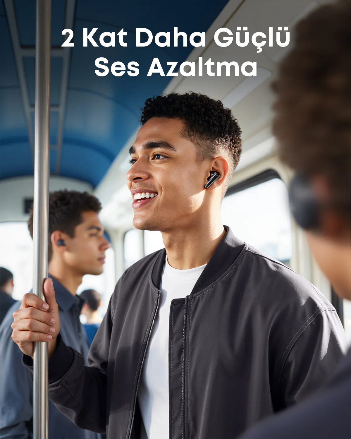 Mężczyzna w słuchawkach w pociągu, uśmiechnięty, patrzący przed siebie.