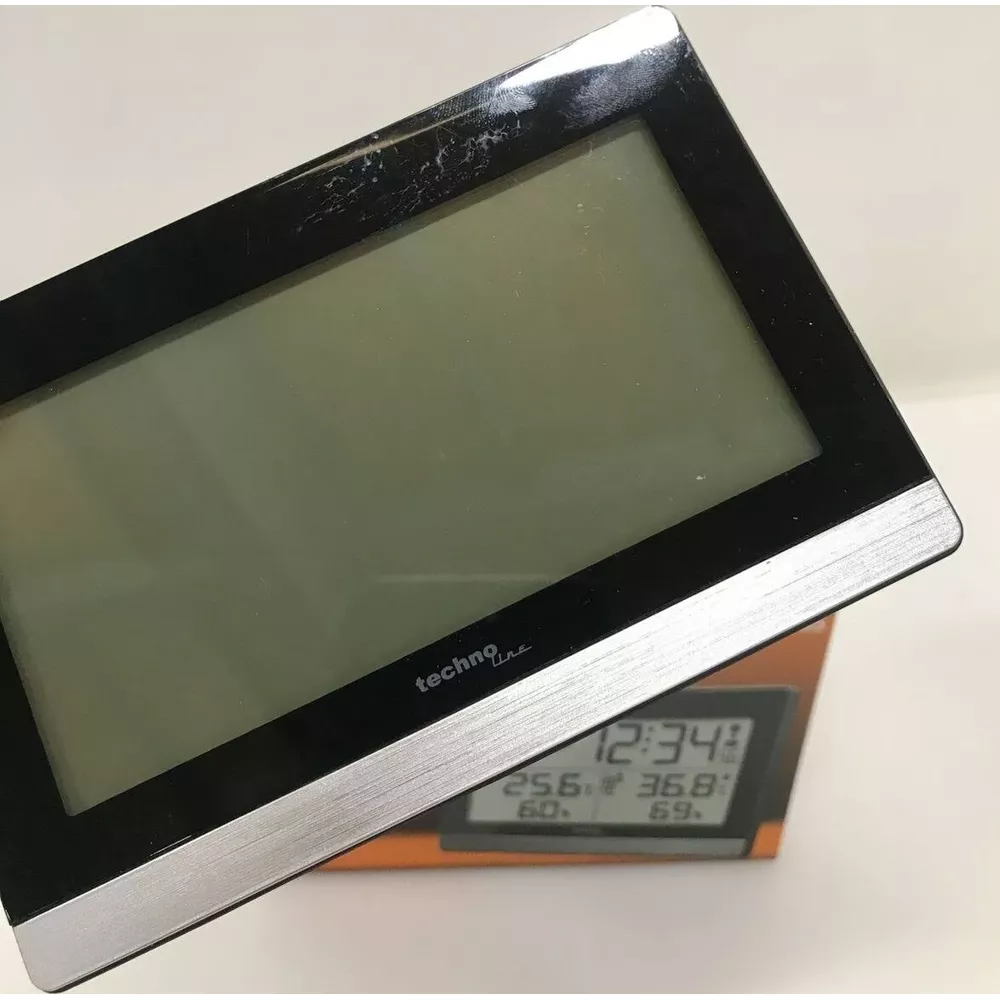 Zegar cyfrowy z czarną ramką wyświetla czas, temperaturę i wilgotność.