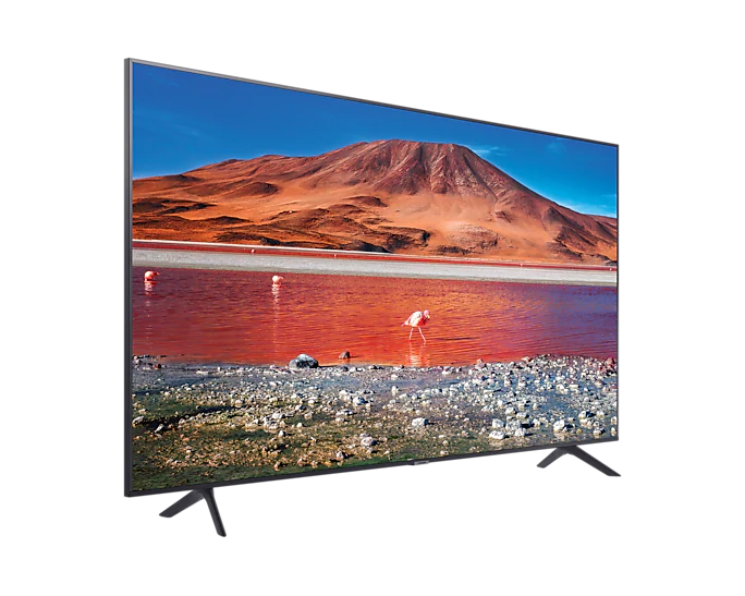 Telewizor wyświetla krajobraz: czerwone jezioro, flamingi, skalisty brzeg, góry i niebieskie niebo.