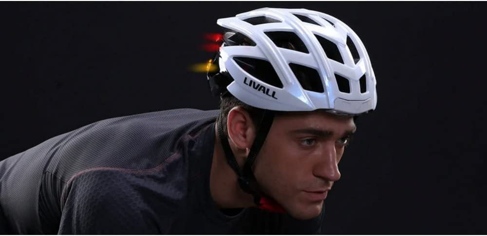 Hombre con casco blanco con luces rojas y amarillas. Fondo negro. Ciclismo.