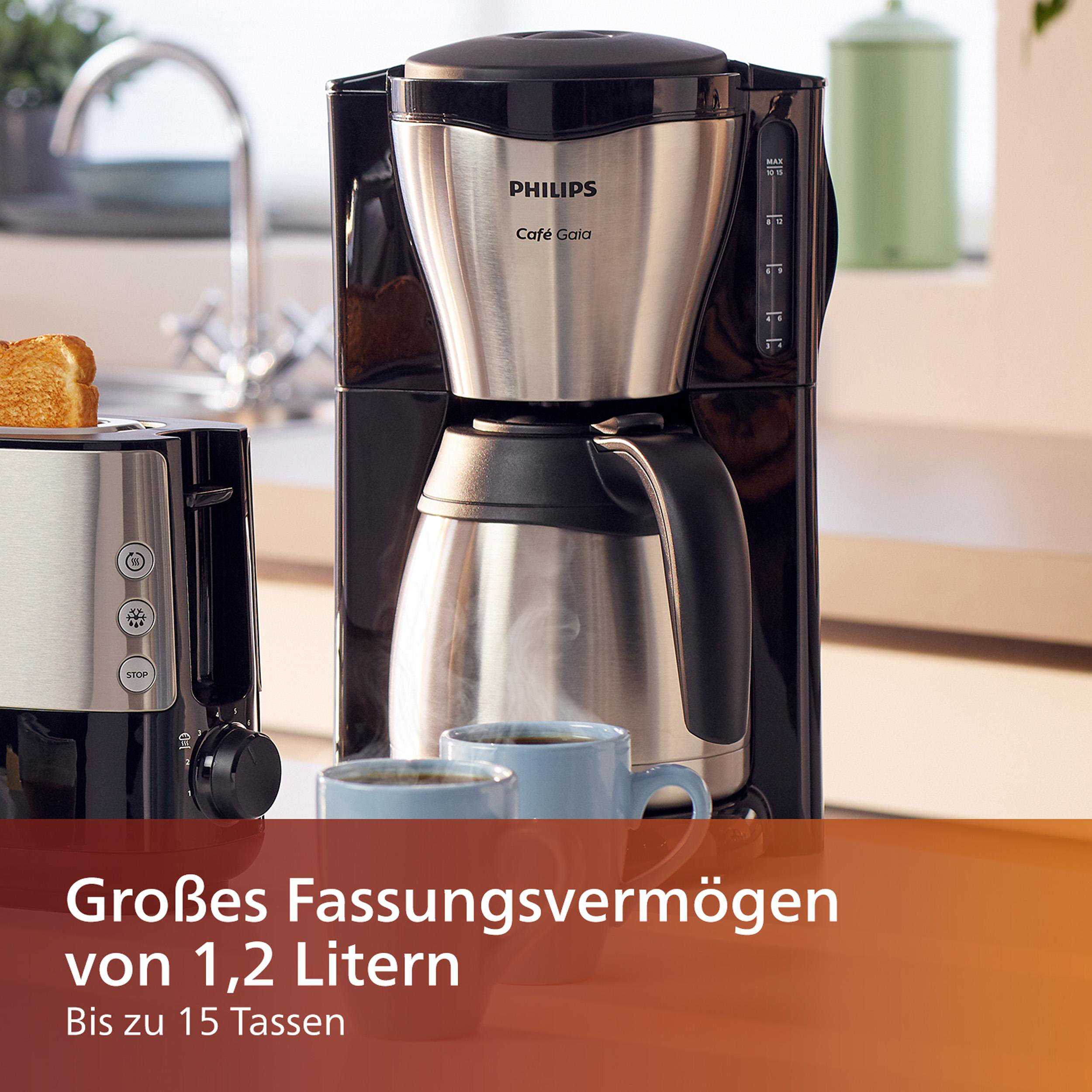 Eine Kaffeemaschine mit schwarzem und silbernem Design und zwei blauen Tassen.