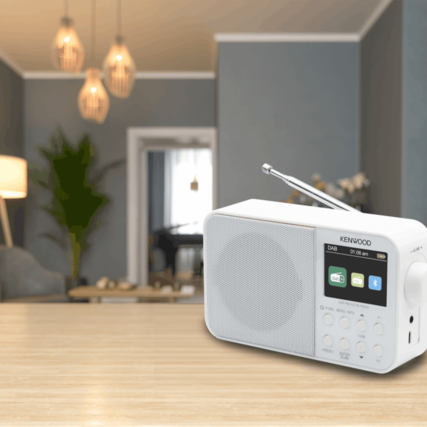 Una radio Kenwood bianca con schermo e pulsanti su un tavolo.