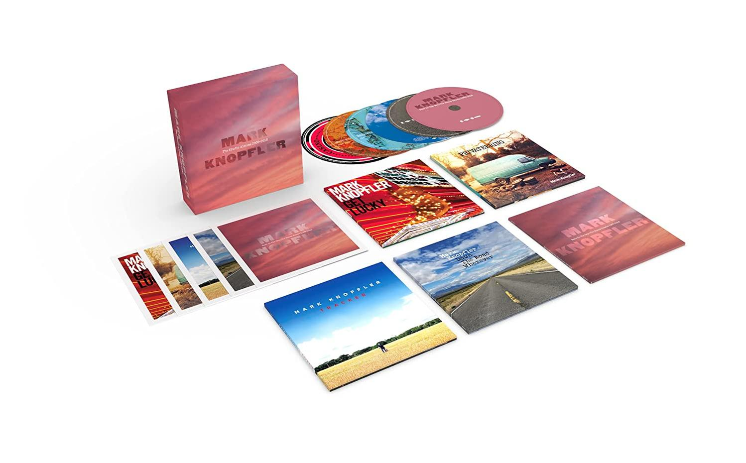 Eine Mark Knopfler Album-Box-Set mit mehreren CD-Covers und CDs auf weißer Oberfläche.