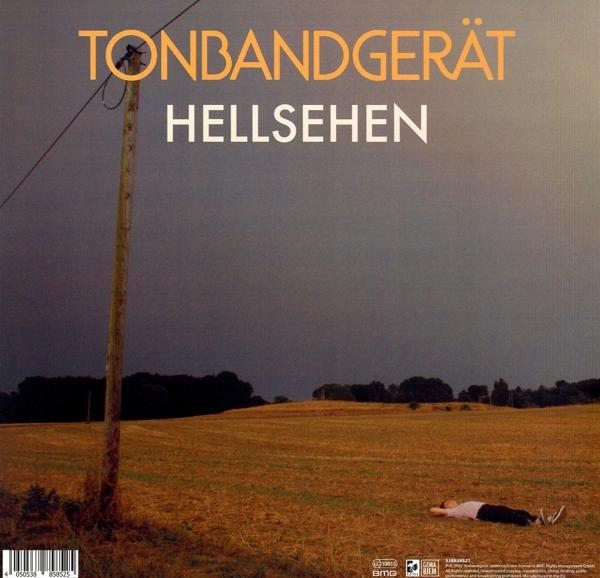 Albumcover. Ein Feld mit einer Person, die darin liegt, einem Strommast und einem bewölkten Himmel.