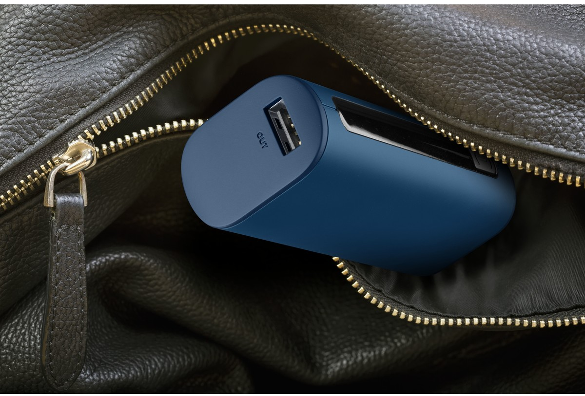 Ein blaues, tragbares Ladegerät in einer schwarzen Ledertasche. Das Ladegerät hat einen USB-Anschluss.