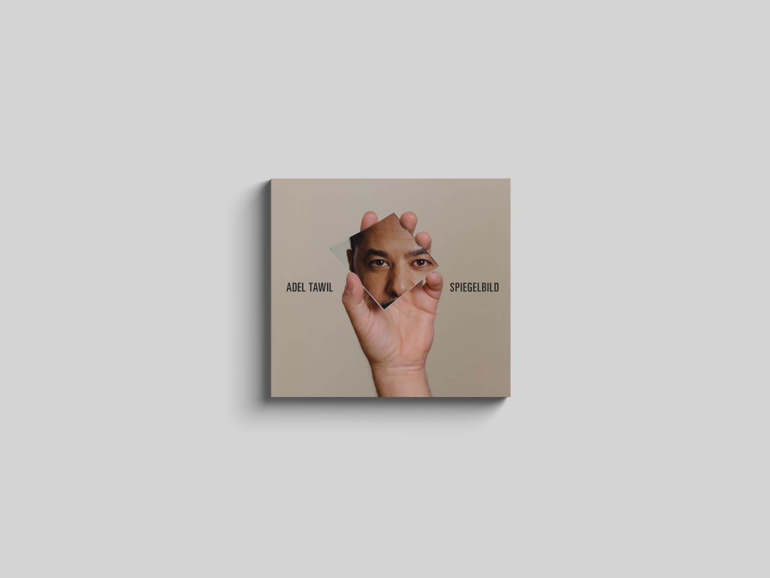 Ein quadratisches Albumcover mit einer Hand, die ein Spiegelfragment hält, das die Augen eines Mannes reflektiert.