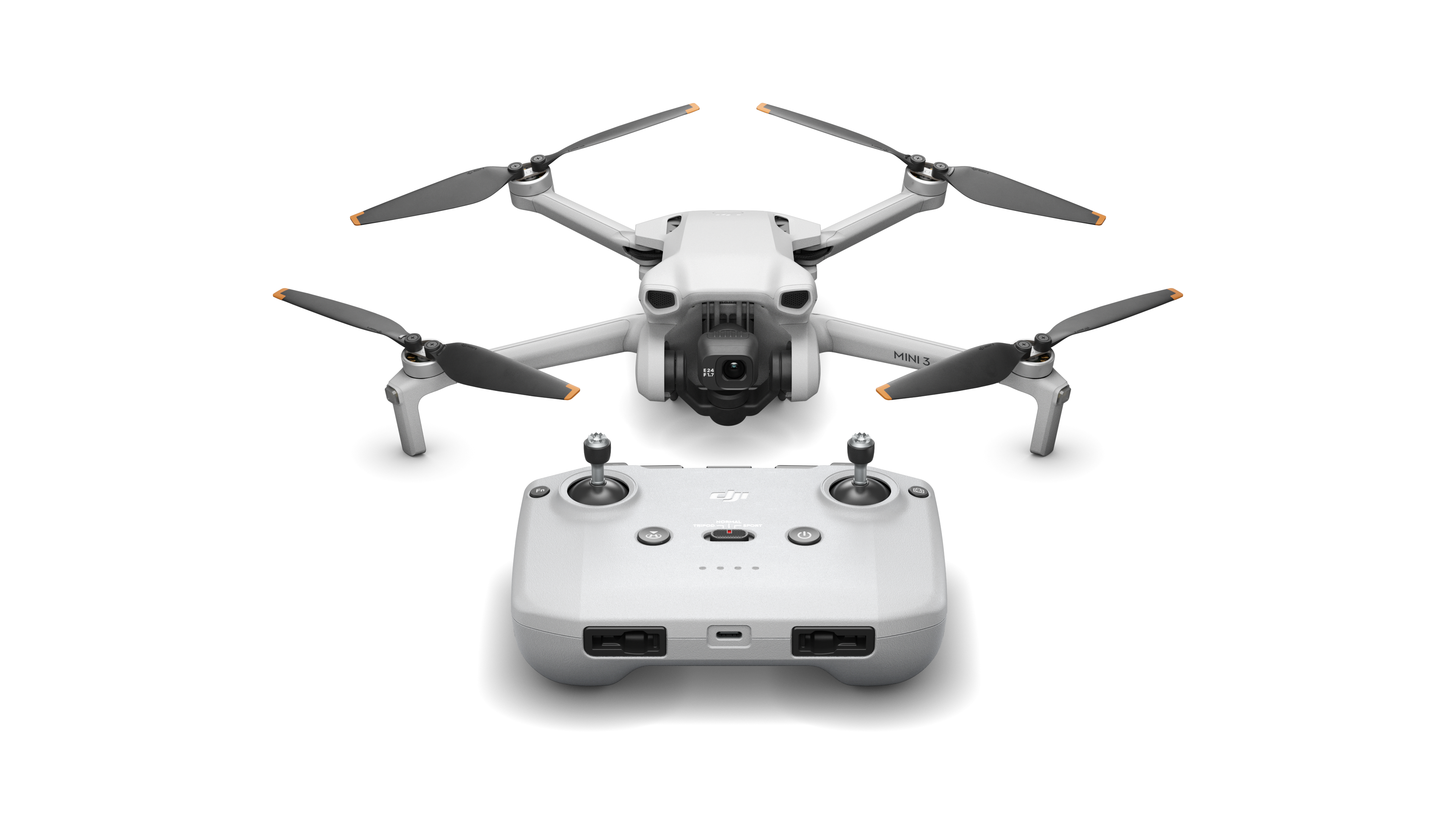 Dron blanco y mando a distancia. El dron tiene cuatro hélices negras.