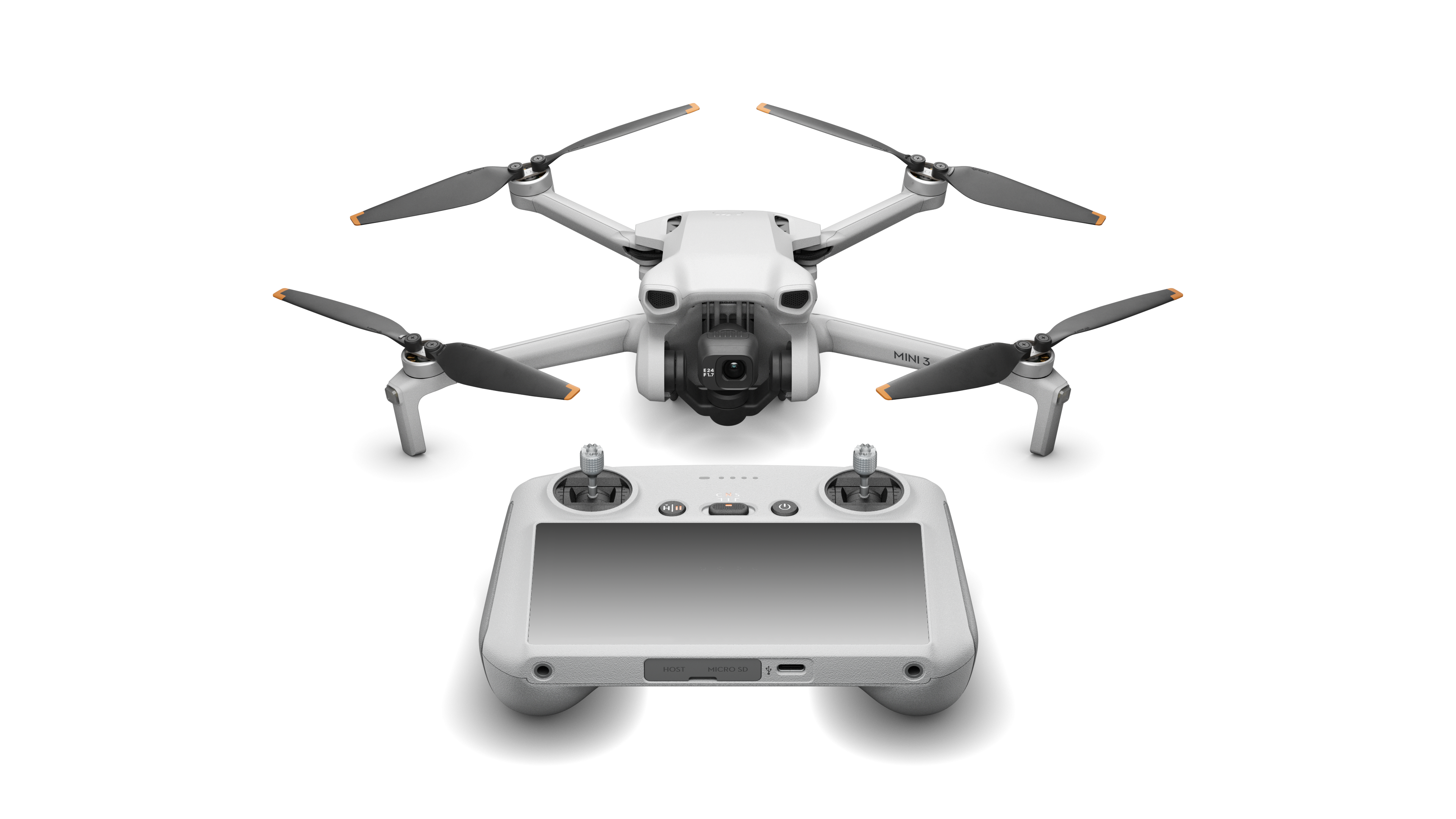 Dron blanco con hélices negras y control remoto sobre fondo negro. El dron está arriba.