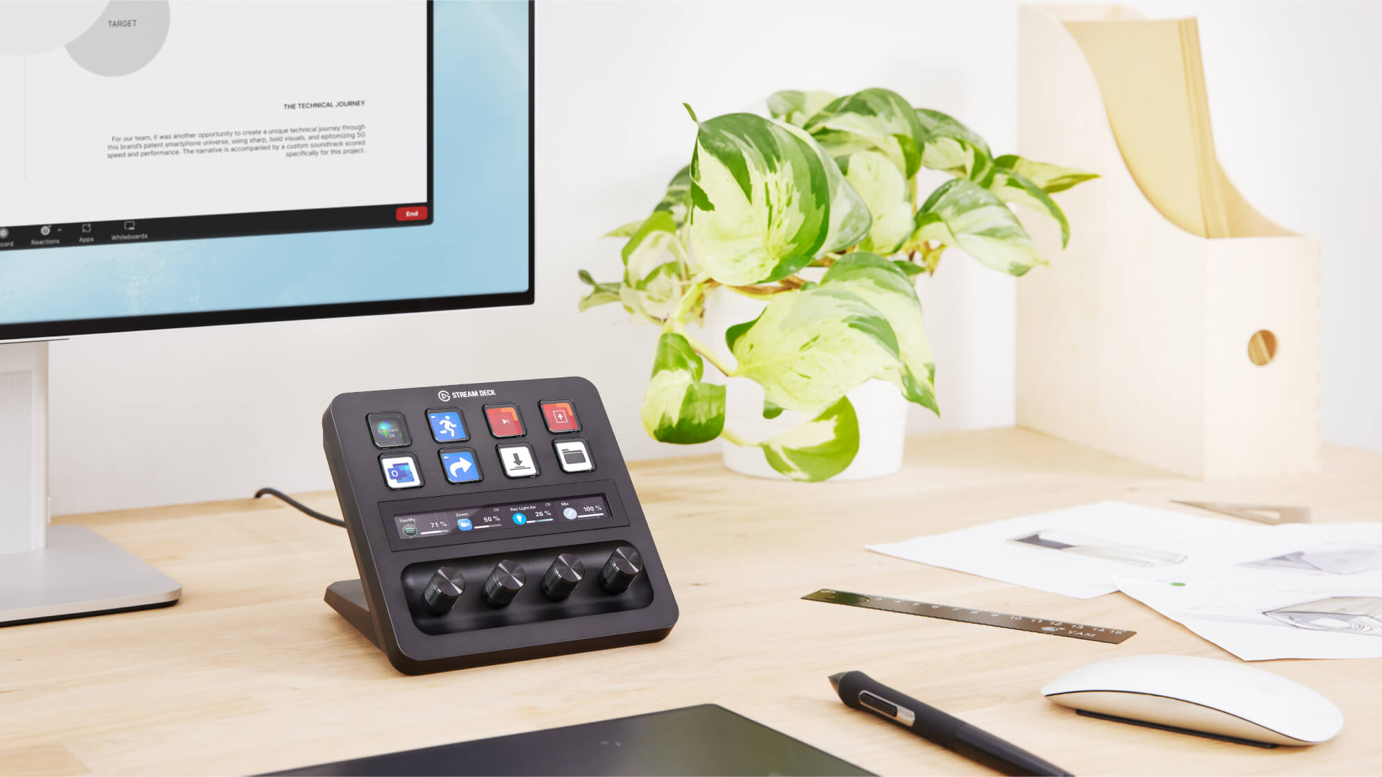 Ein Stream Deck Bedienfeld auf einem Schreibtisch mit Zubehör und einem Computerbildschirm.