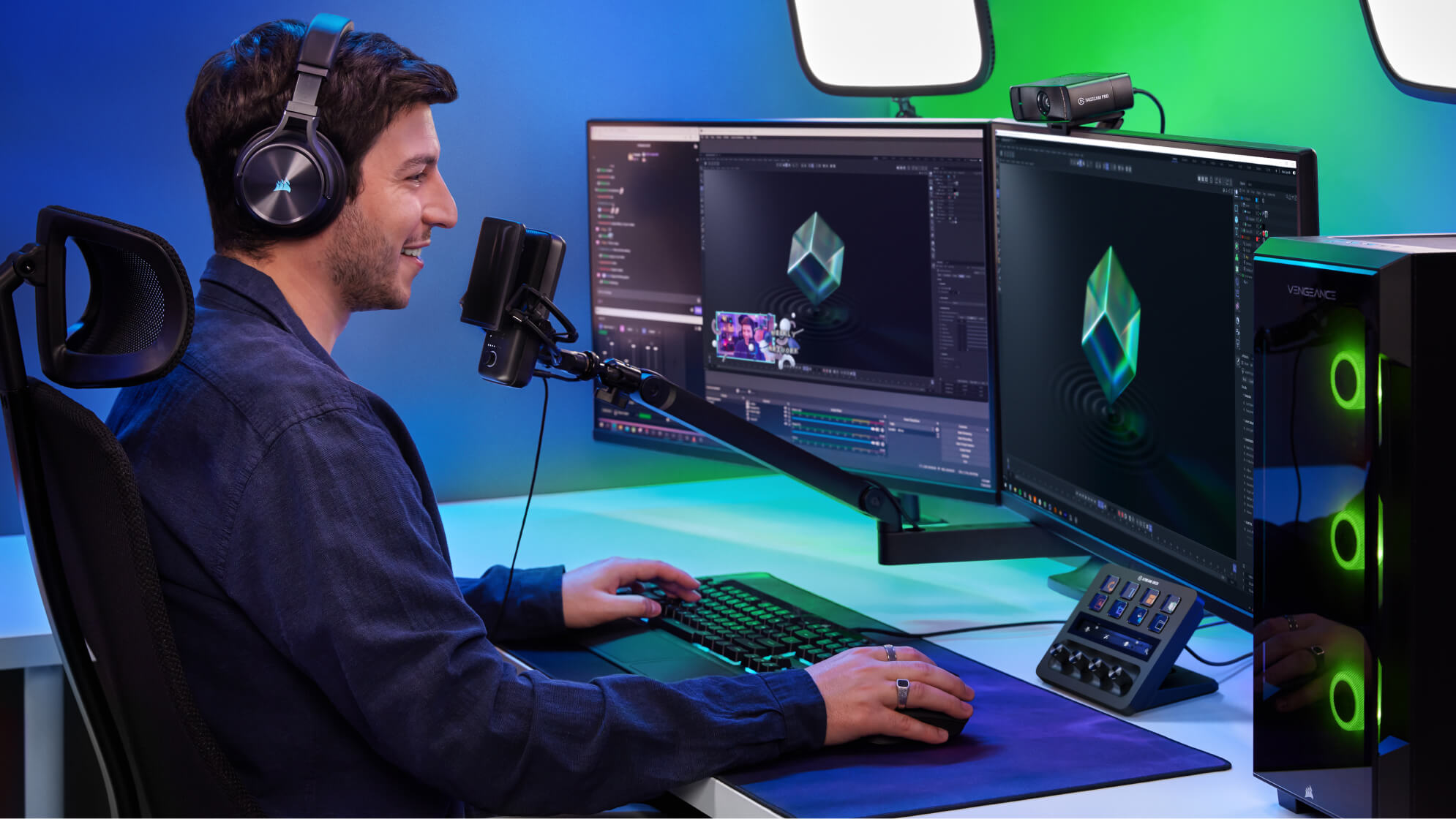 Ein Mann mit Kopfhörern sitzt an einem Schreibtisch mit zwei Monitoren, Mikrofon und Streaming-Ausrüstung.