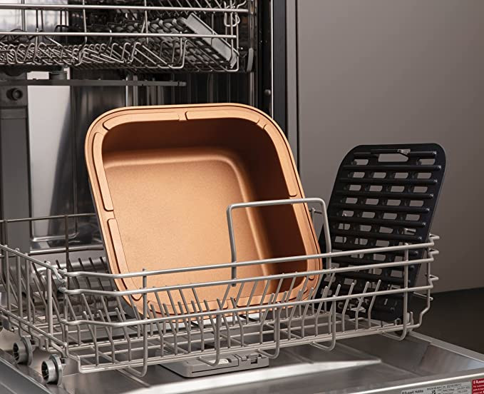 Dishwasher with a copper-colored baking dish. Black rack is also visible inside.