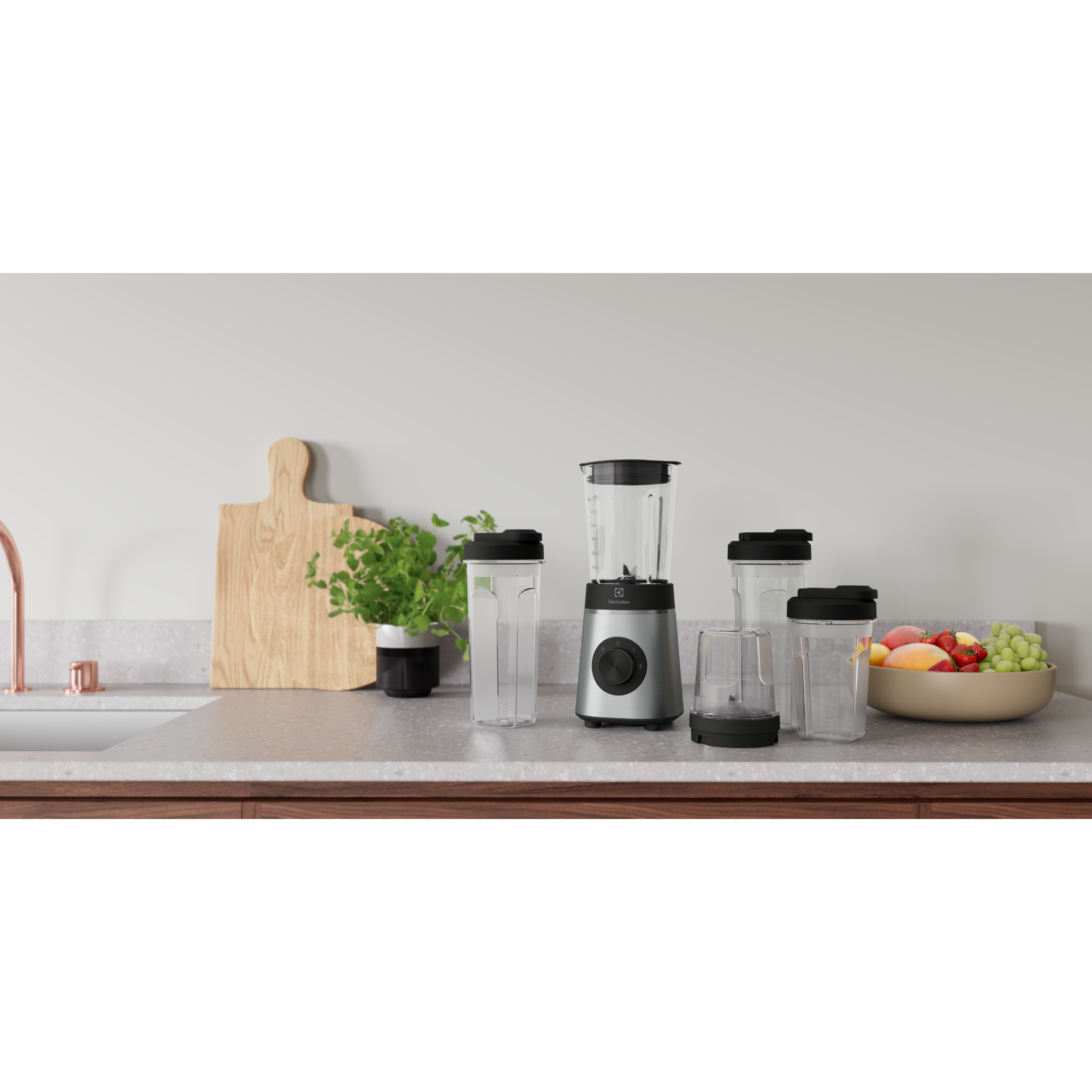 Blender, bardak, kesme tahtası ve meyve kasesi bulunan bir mutfak tezgahı.