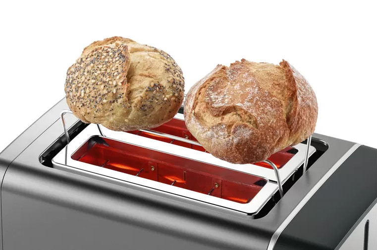 Toaster with bread. Two round loaves of bread in toaster.