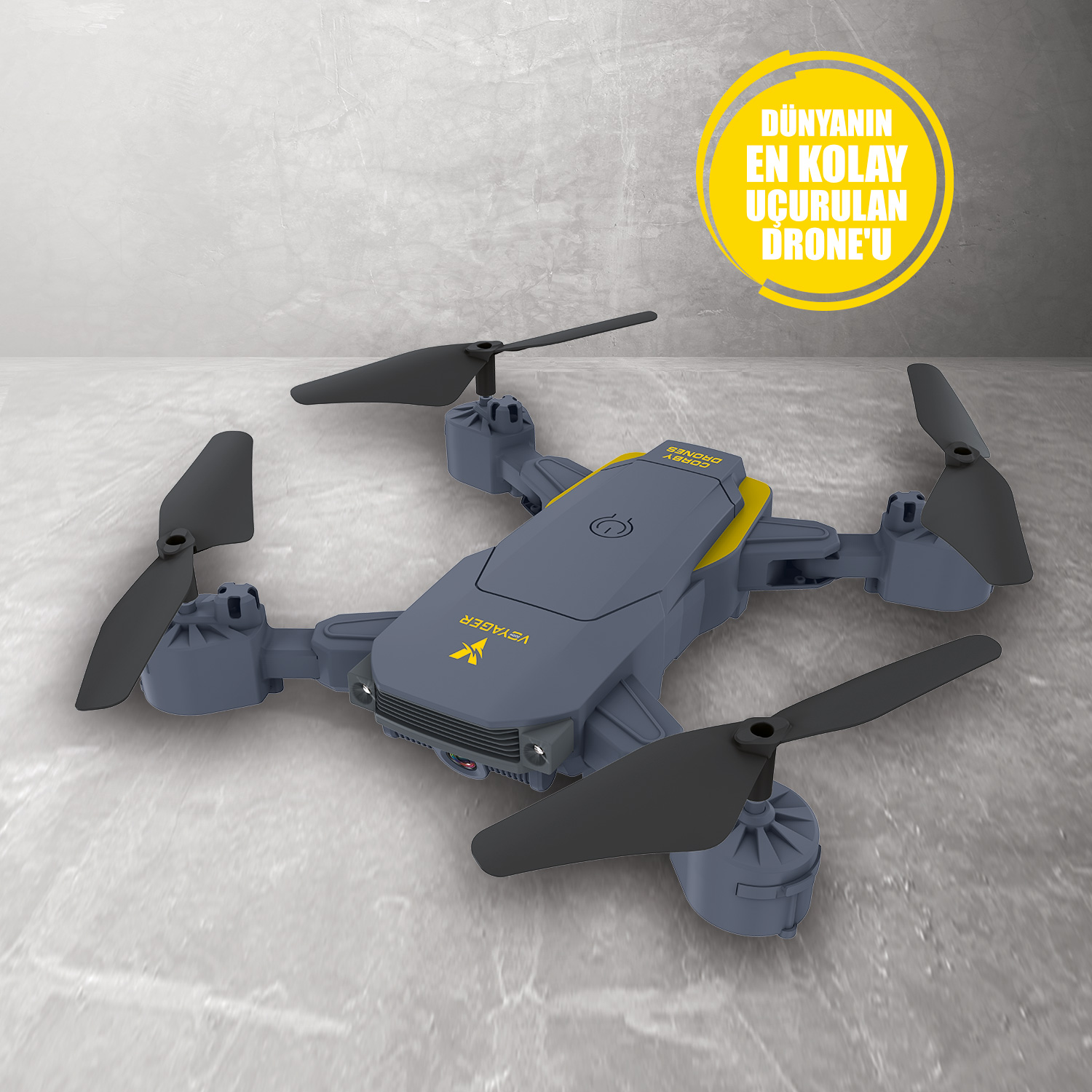 Beton yüzey üzerinde gri ve sarı drone. Metin: Dünyanın en kolay uçurulan drone'u.