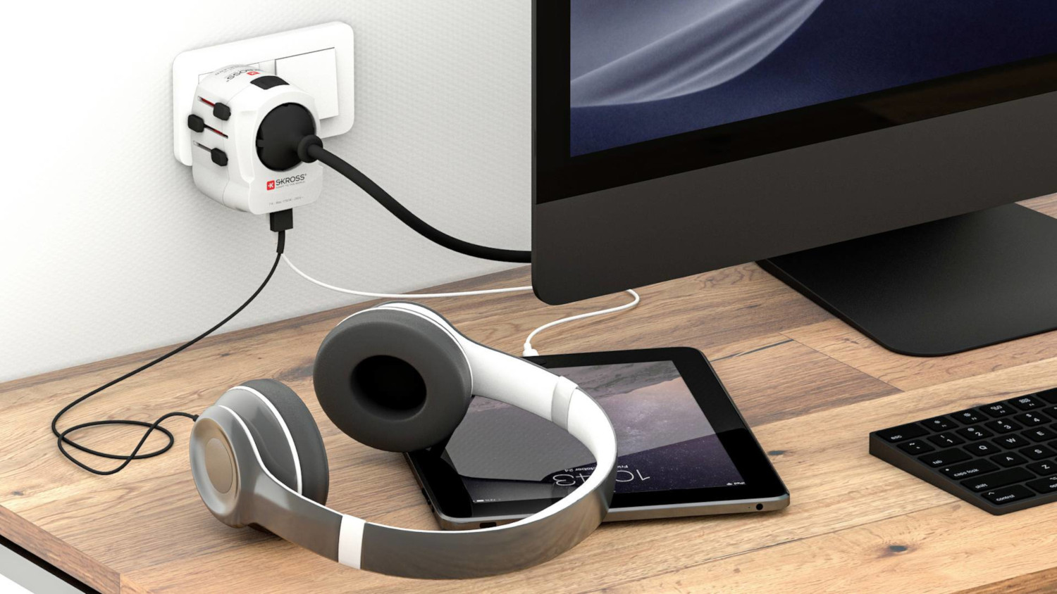 Bureau-opstelling met koptelefoon, tablet, oplaadadapter in stopcontact.