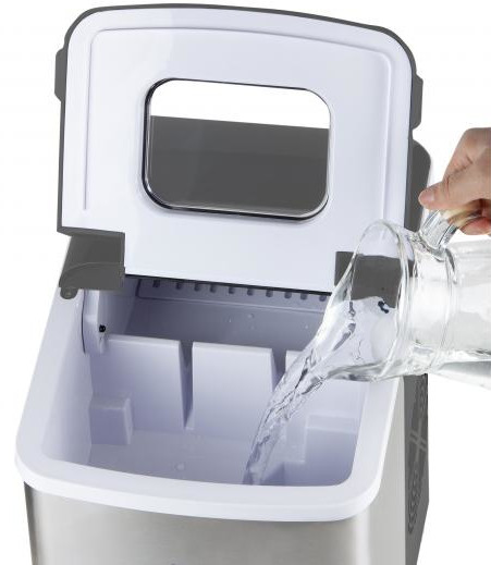Ice maker being filled with water from a pitcher.