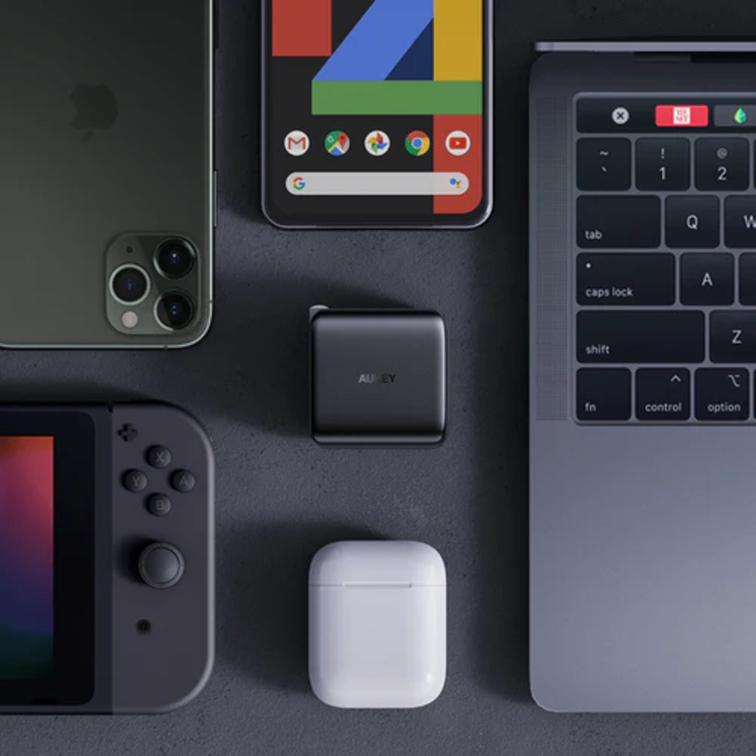 Vista dall'alto di dispositivi elettronici: iPhone, telefono Android, adattatore di alimentazione, Switch, AirPods e laptop.