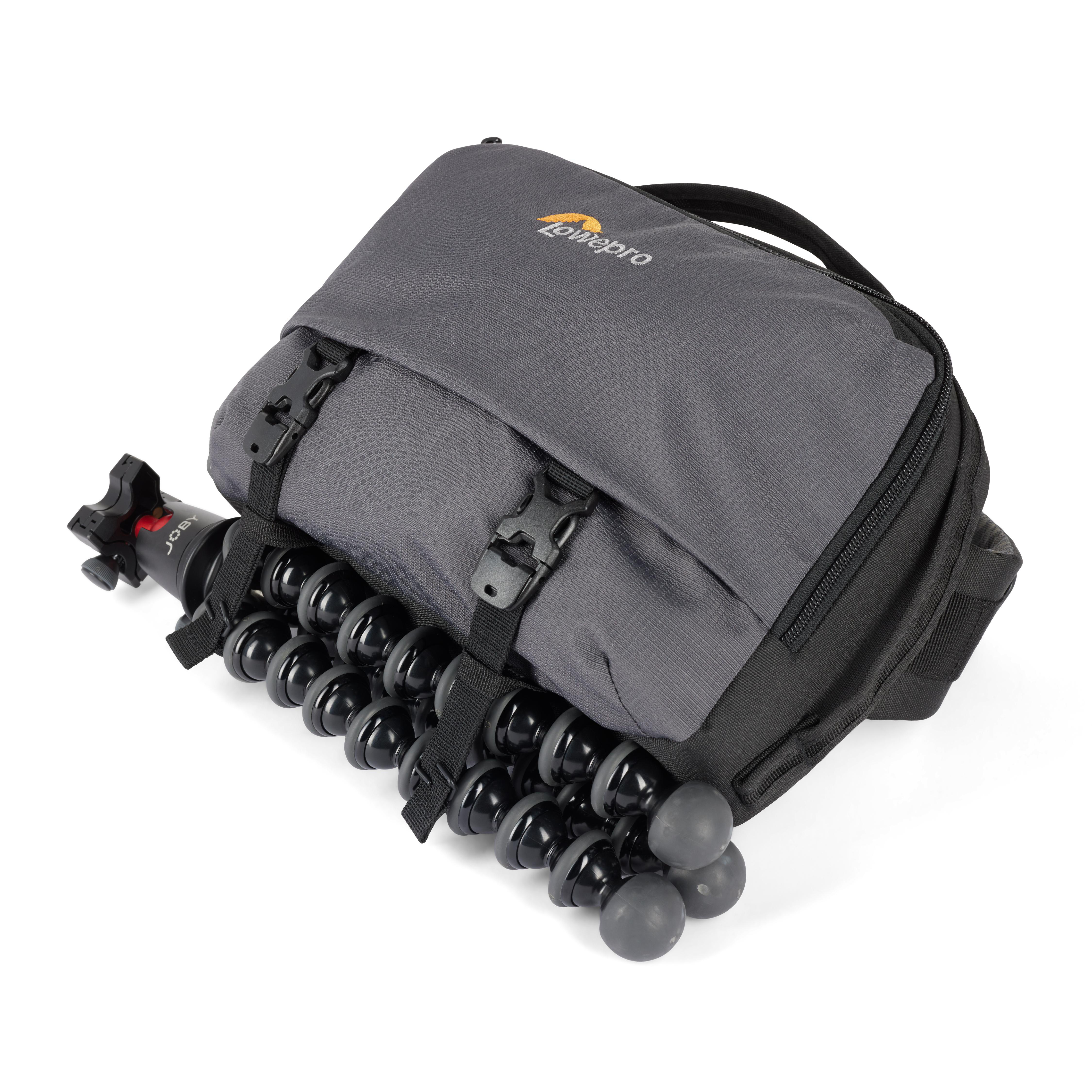 Graue Kameratasche mit flexiblem Stativ. Tasche ist geschlossen und hat Riemen.