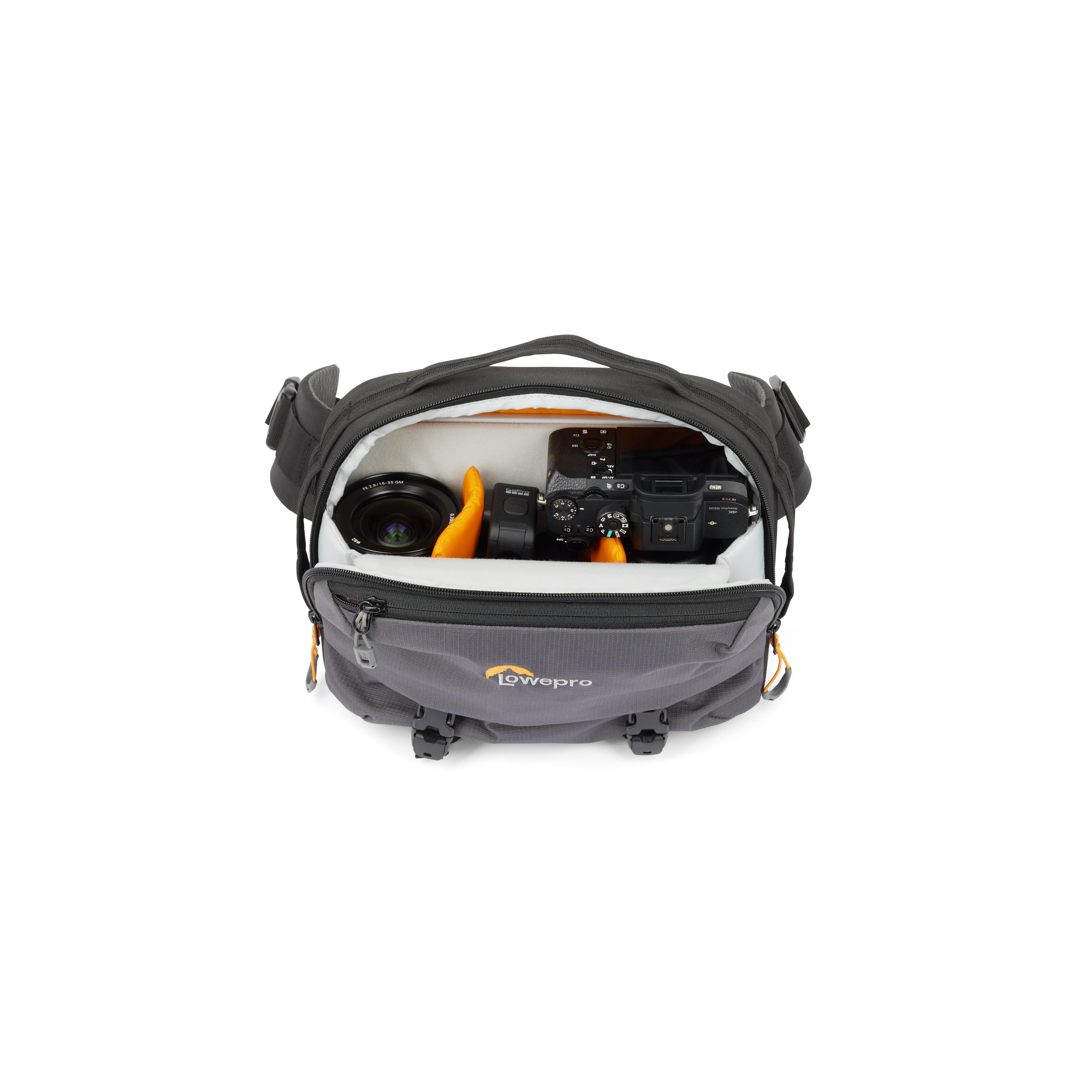 Kamera und Objektiv in einer Lowepro-Kameratasche. Weißer Hintergrund.