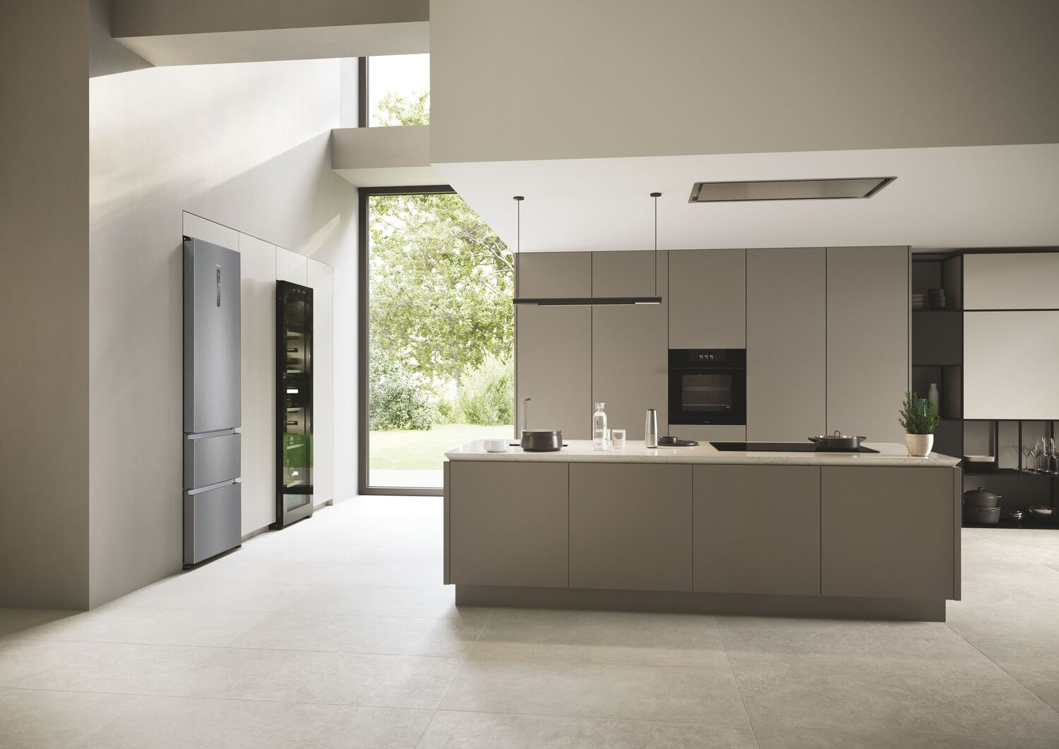 Cocina moderna con nevera de acero inoxidable, gabinetes oscuros y ventanas grandes.