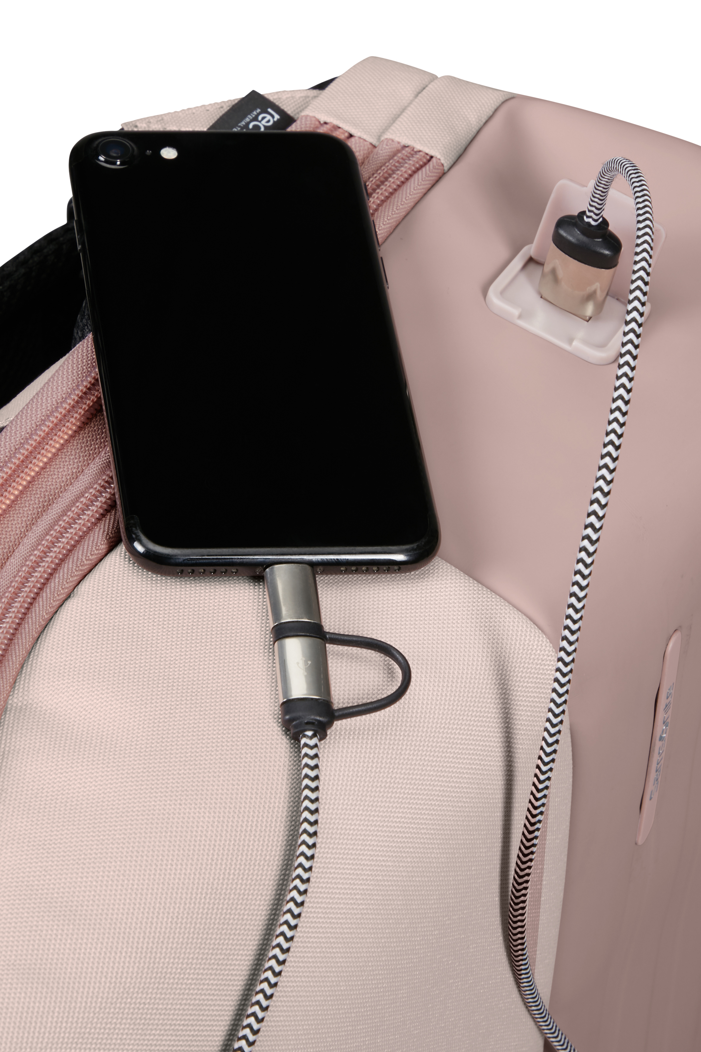 Şarj cihazı takılı bir telefon, şarj portlu bir sırt çantasının içinde.