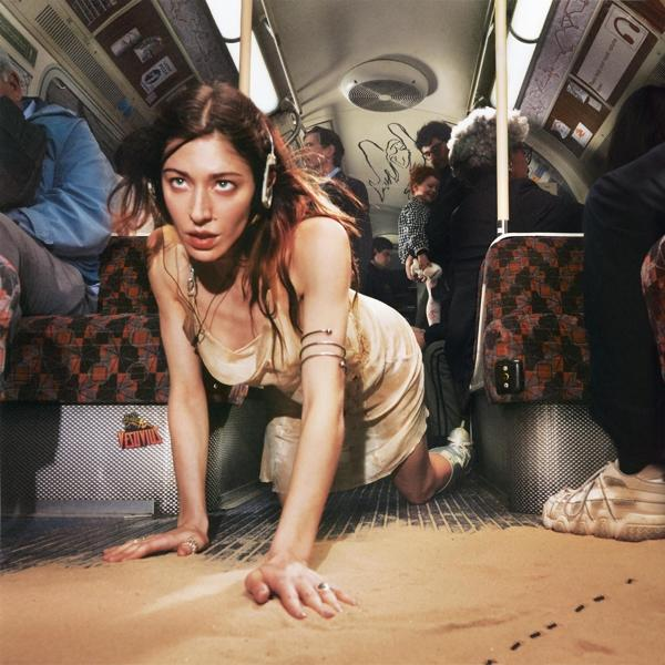 Frau kriecht auf Boden, Leute im Hintergrund, U-Bahn-Innenraum.