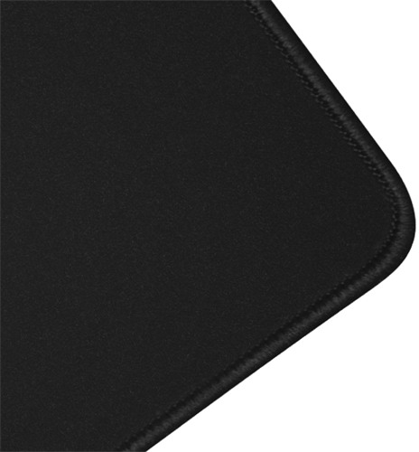 Tapis de souris noir, gros plan sur le coin. Surface noire avec bord cousu.