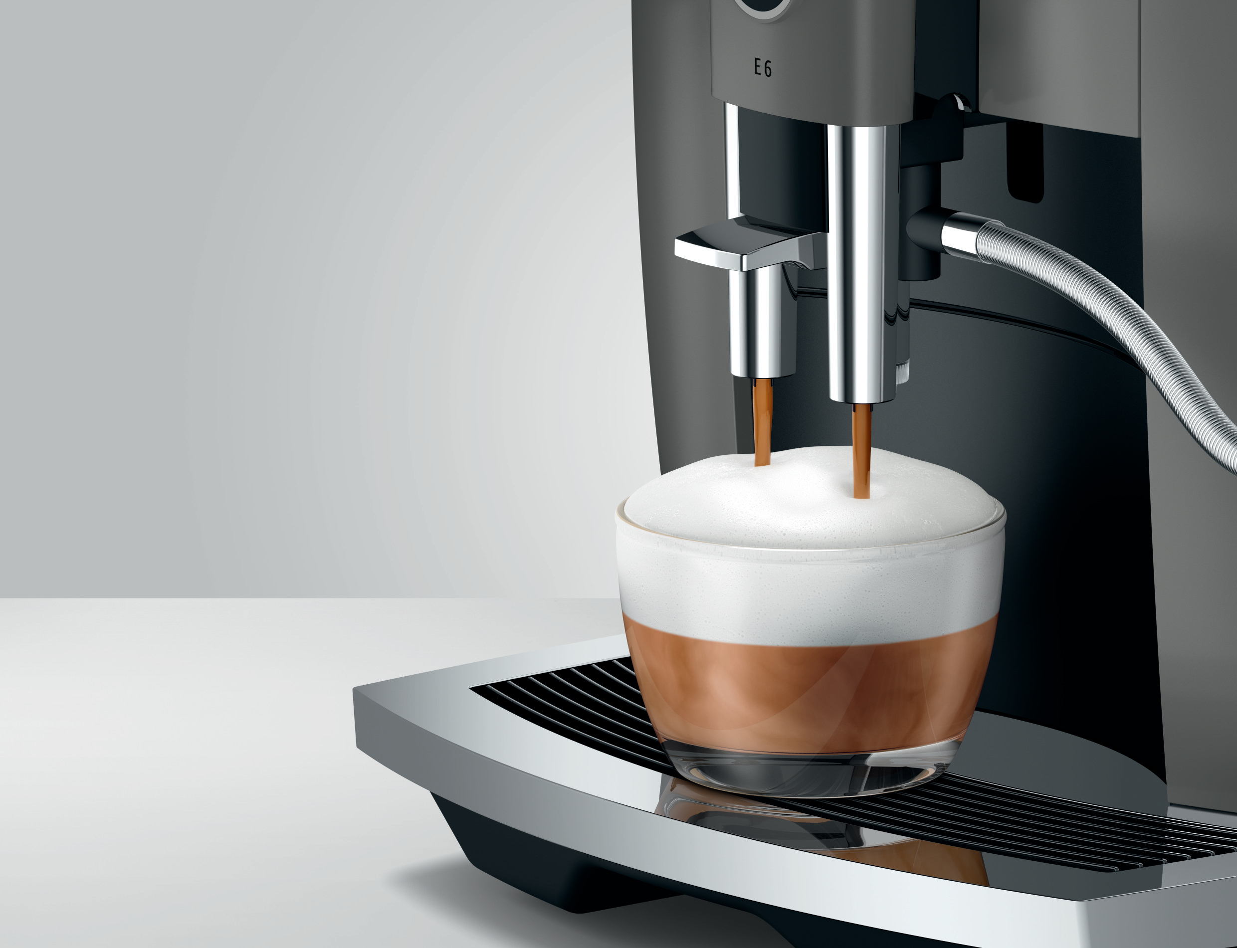 Espressomaschine, die Kaffee mit Schaum in eine Glastasse gießt.