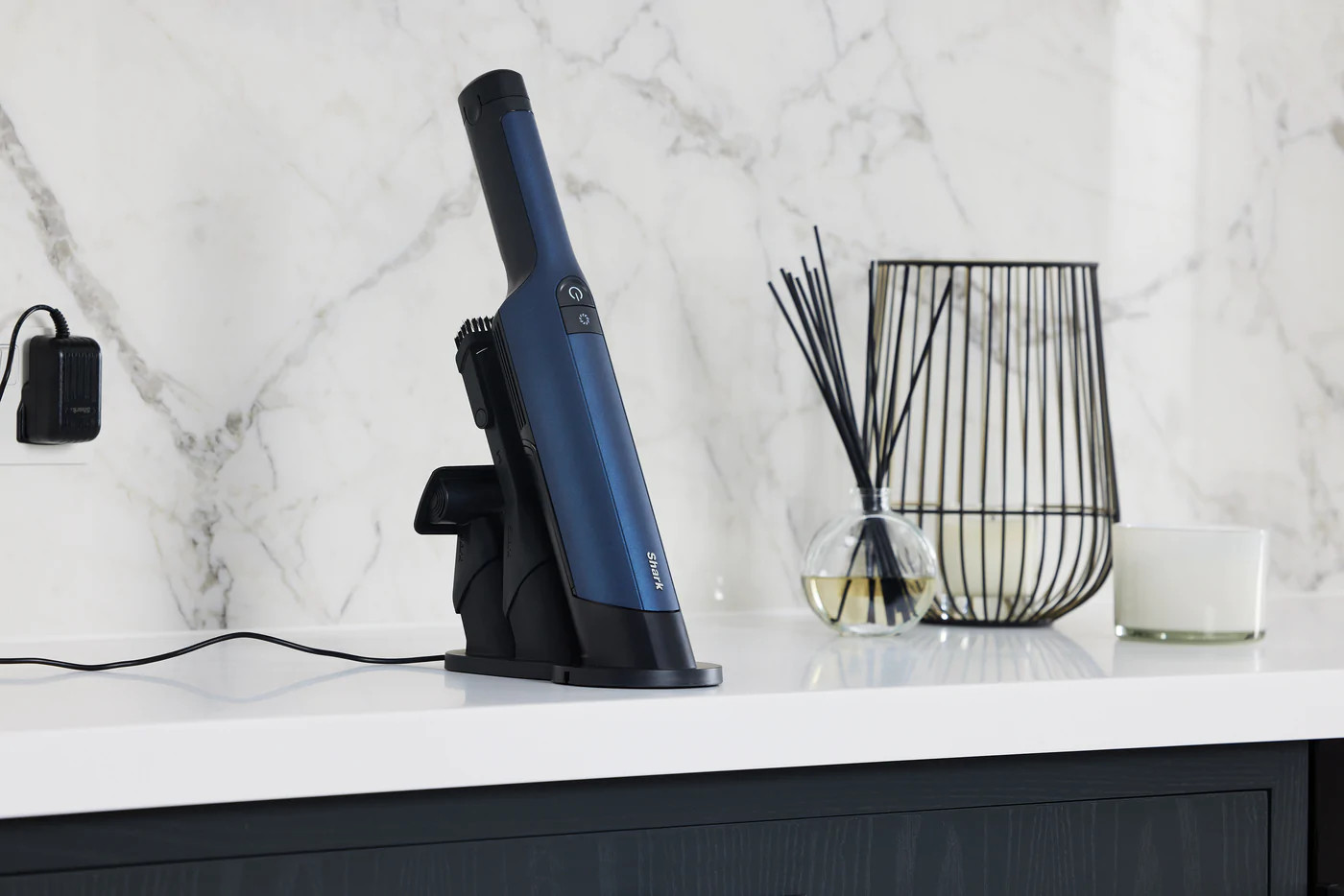 Aspirateur et station de charge sur un comptoir blanc.