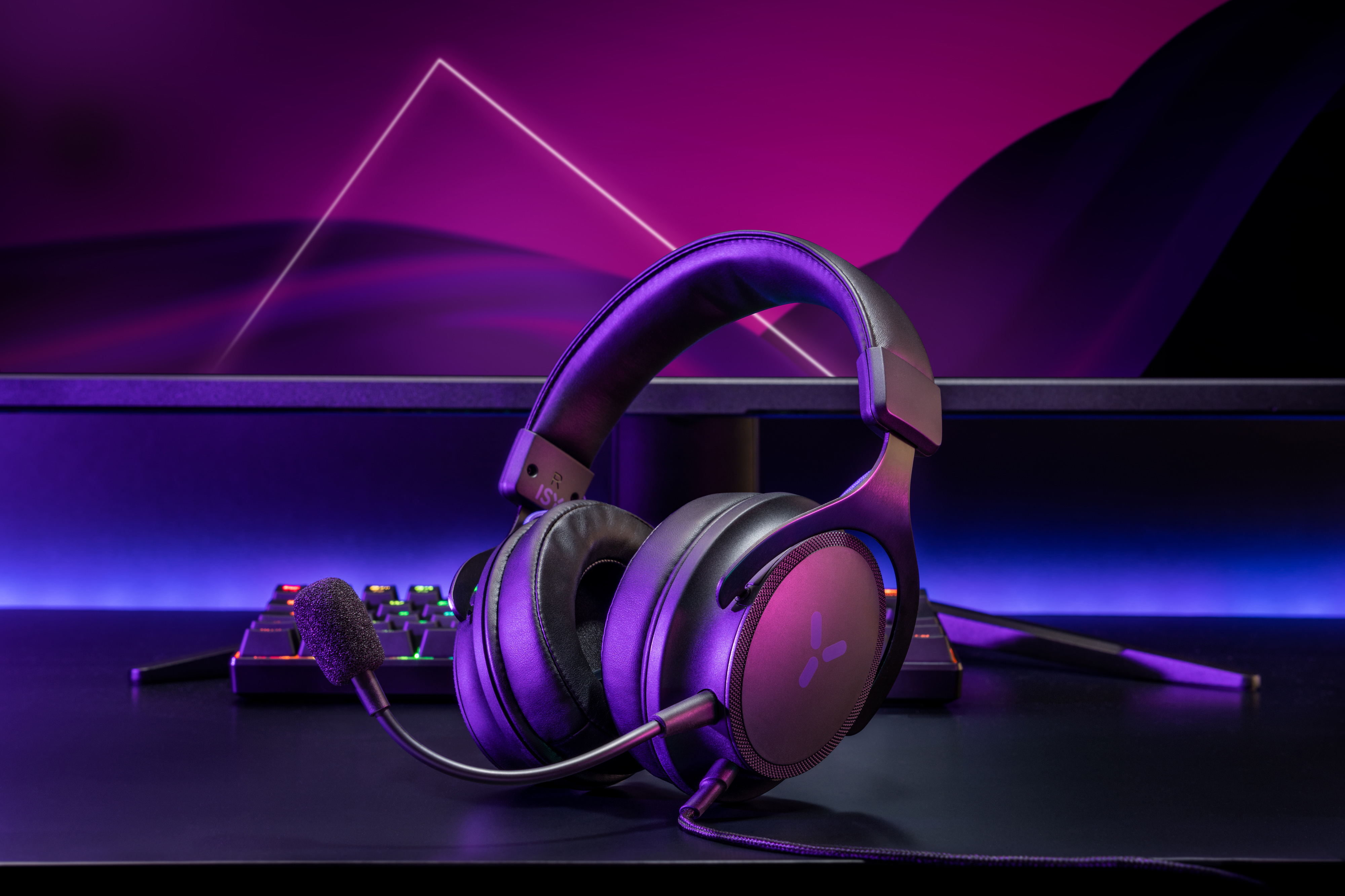 Ein Gaming-Headset liegt auf einem Schreibtisch, beleuchtet mit lila Lichtern.