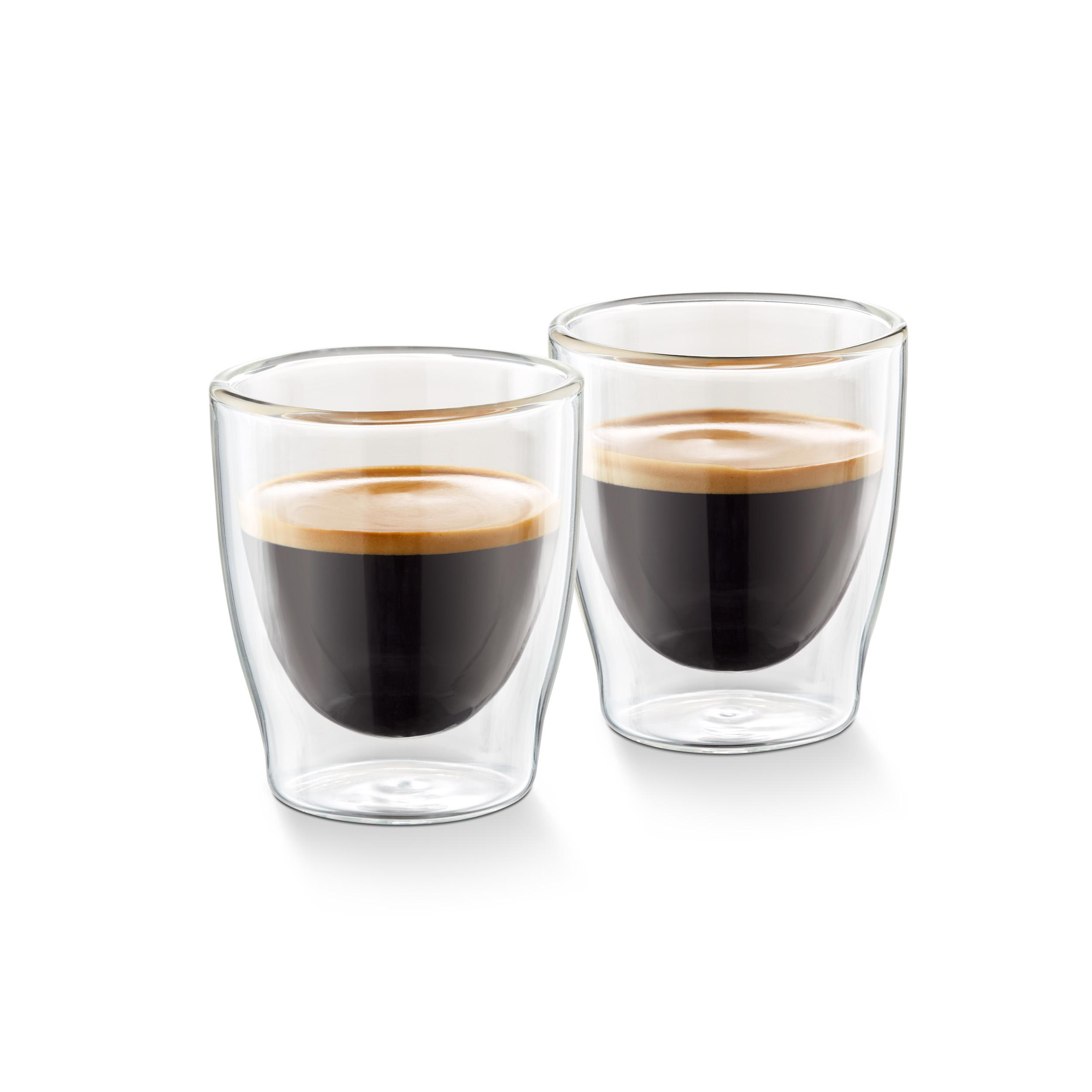 Zwei klare Gläser gefüllt mit dunklem Kaffee auf weißem Hintergrund. Nahaufnahme.