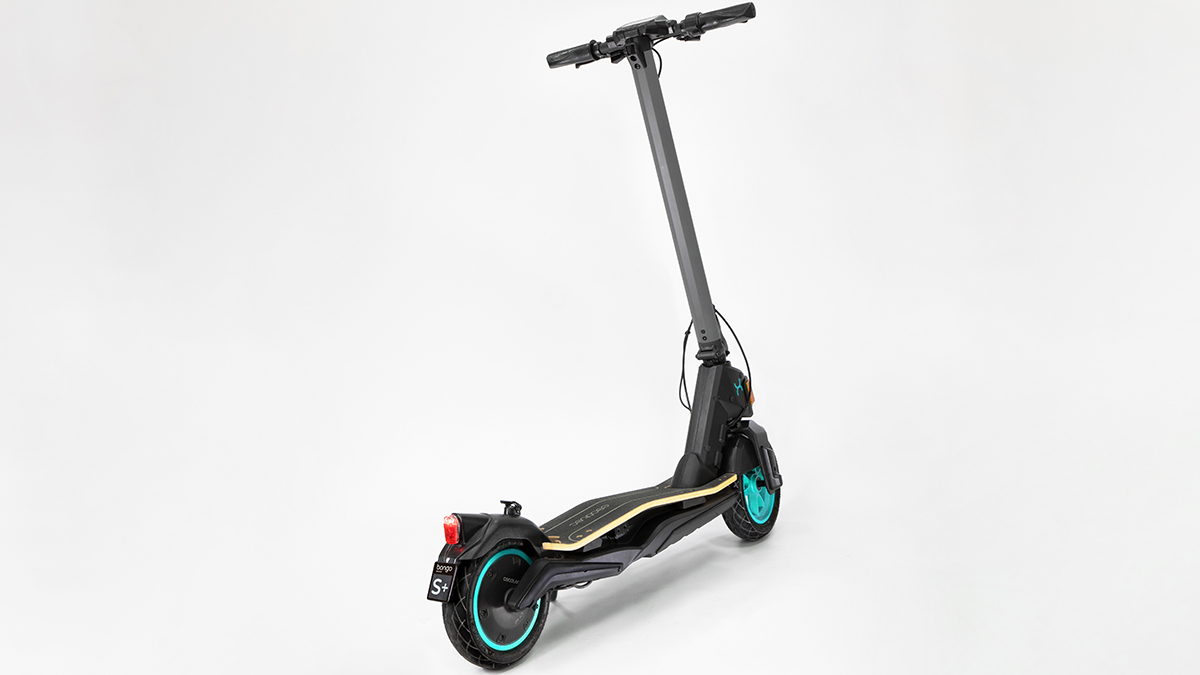 Scooter eléctrico negro y verde azulado sobre fondo blanco. Manillar y ruedas visibles.