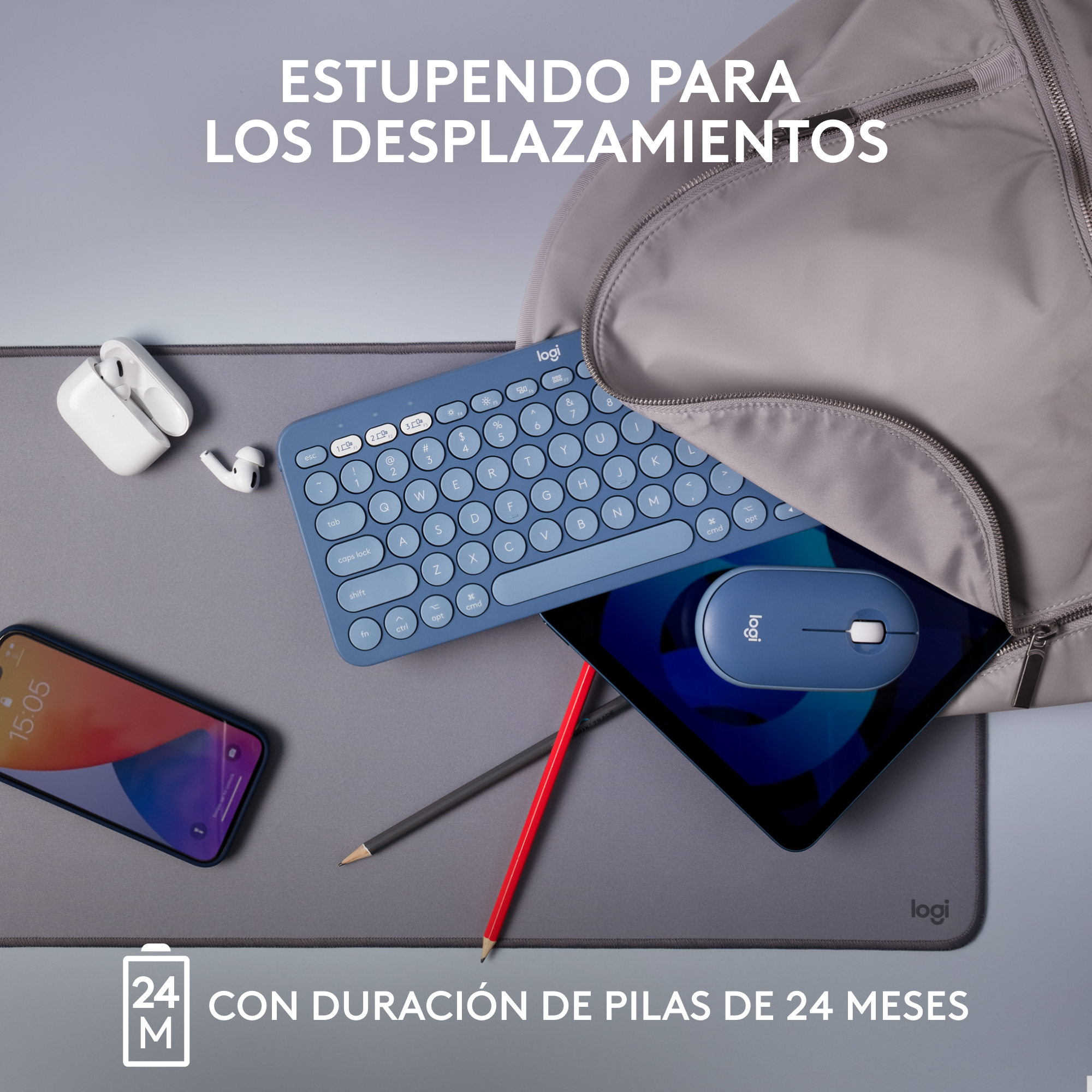Una tableta, un teclado y un ratón están sobre una superficie gris. Un teléfono y una bolsa están a un lado.