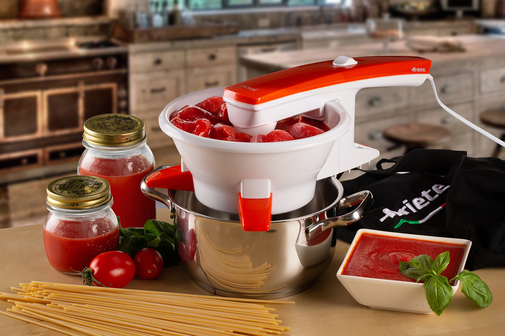 Escena de cocina con máquina procesadora de tomate, frascos e ingredientes.