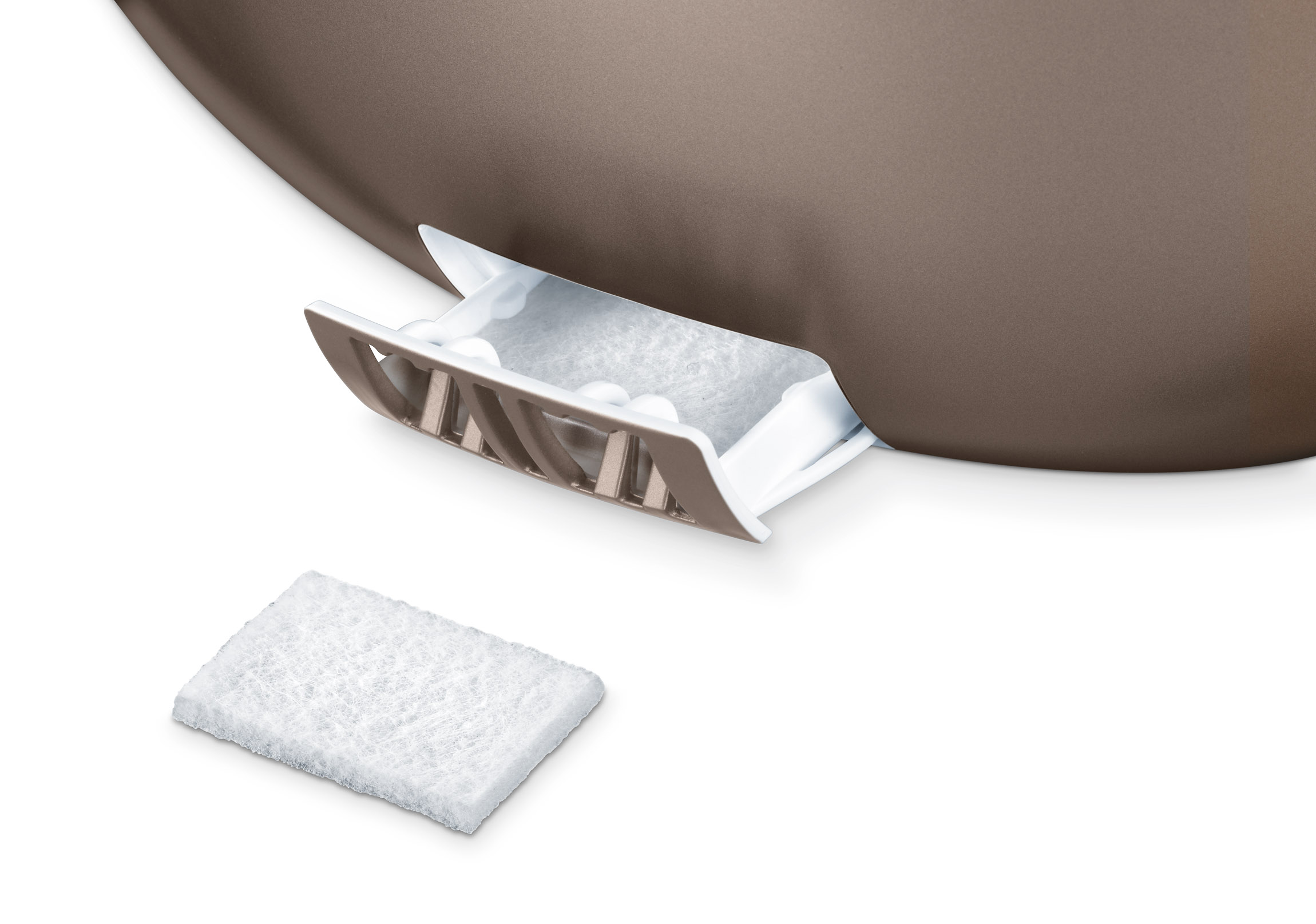 Primer plano de un dispositivo blanco y marrón con una bandeja extraída y una almohadilla al lado.